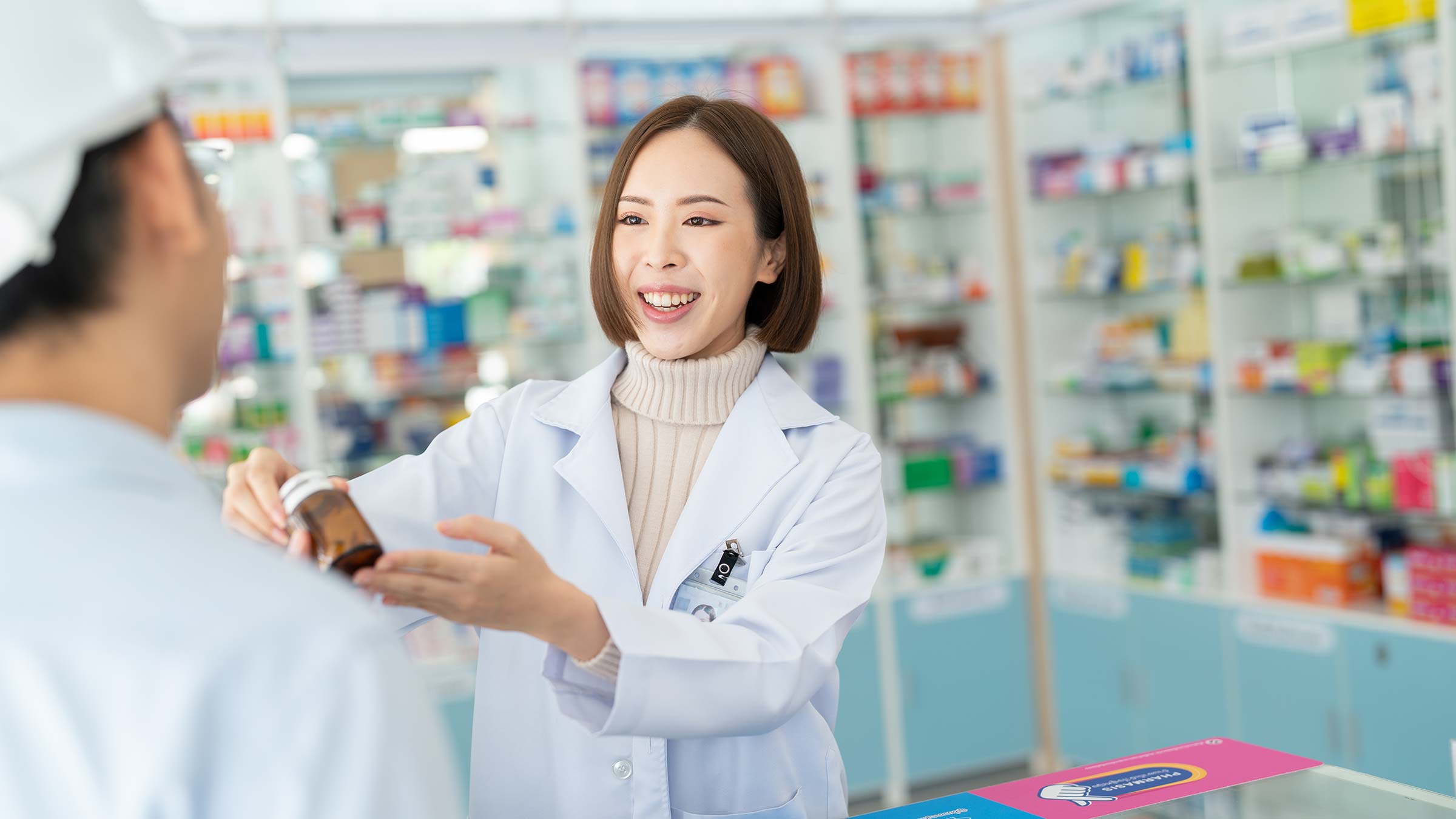 A pharmacist handing medication to a patient in the pharmacy