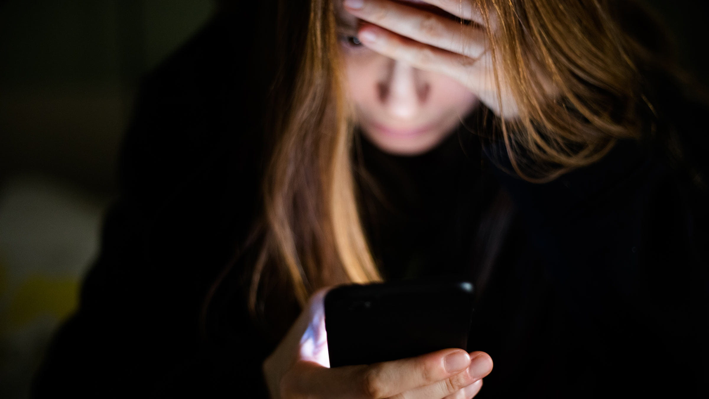 A woman scrolling on her phone in the middle of the night