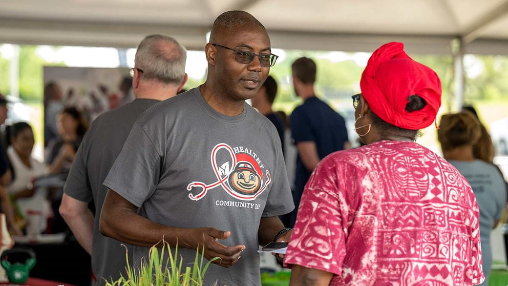 Dr. Doubeni talking to a visitor at a Healthy Community Day