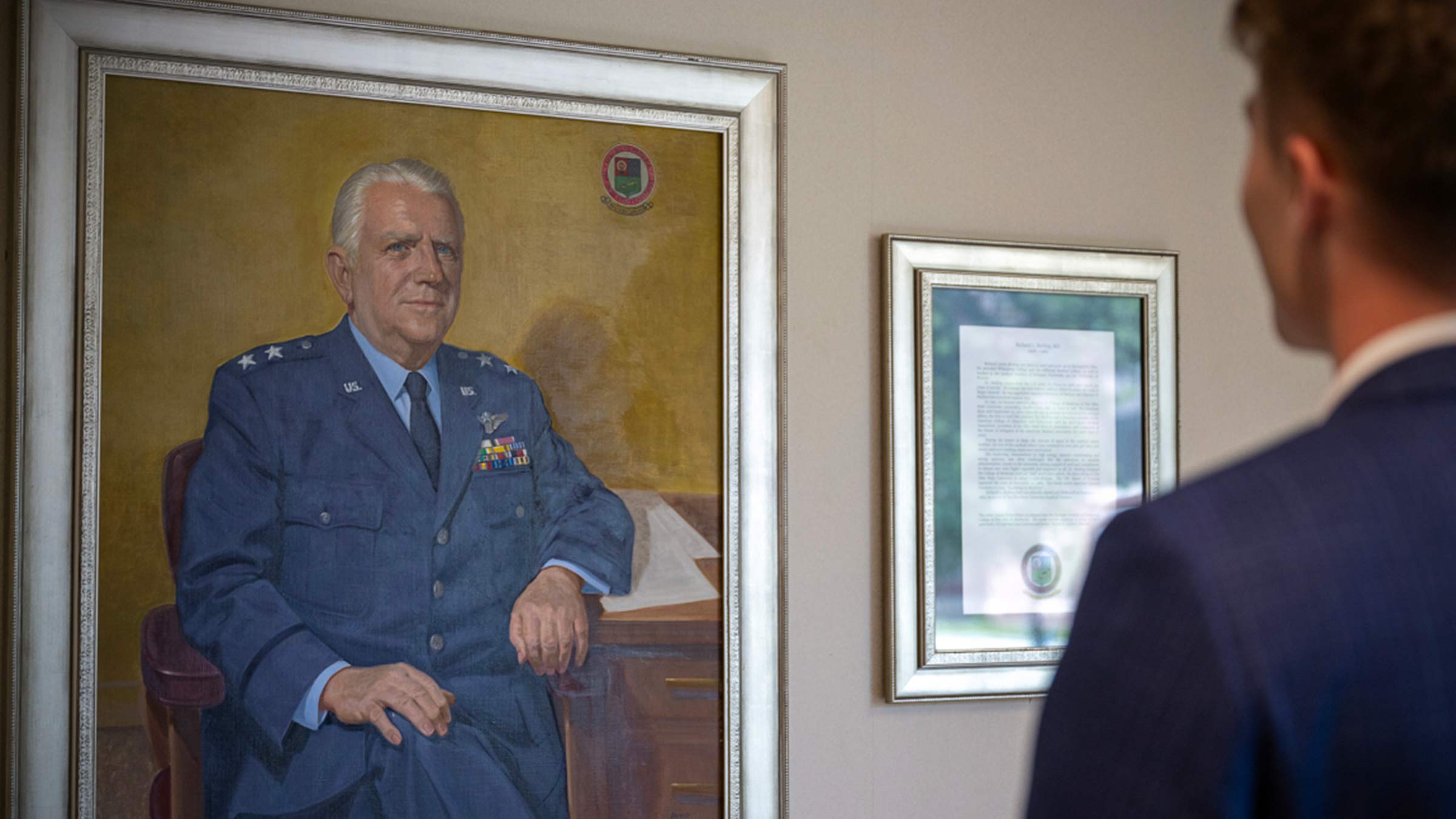 Collin Todd looking at the portrait of Richard Meiling, MD