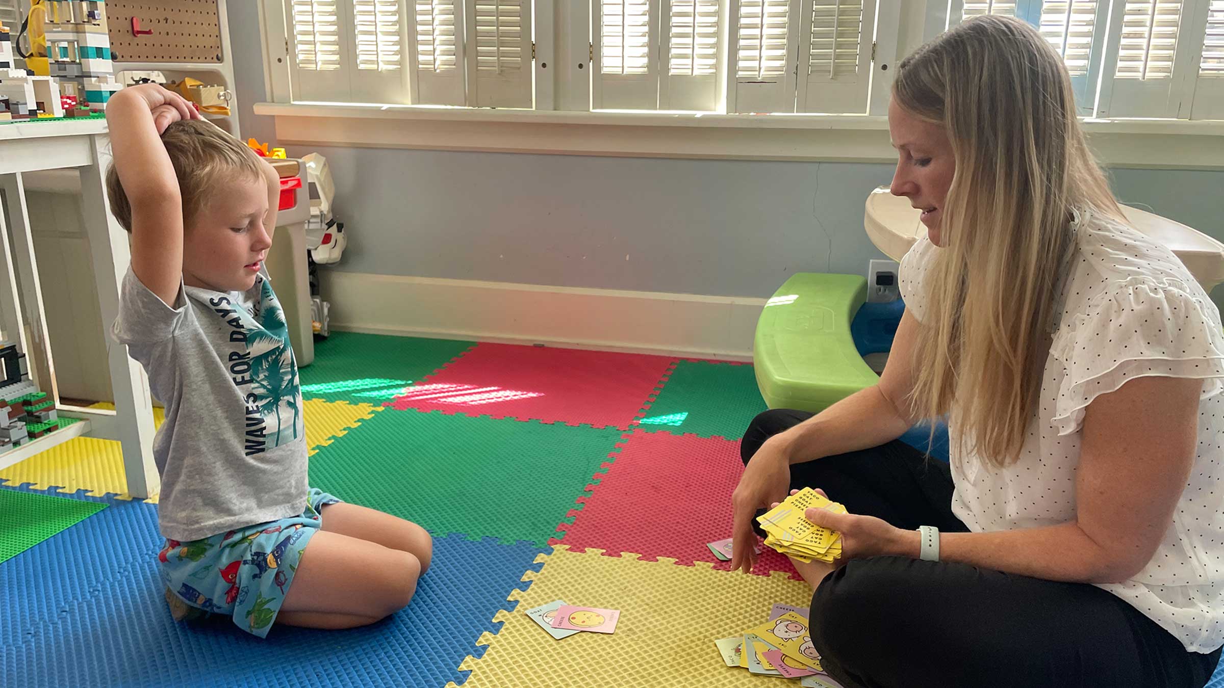 Kate Gawlik, DNP, plays a card game with her young son