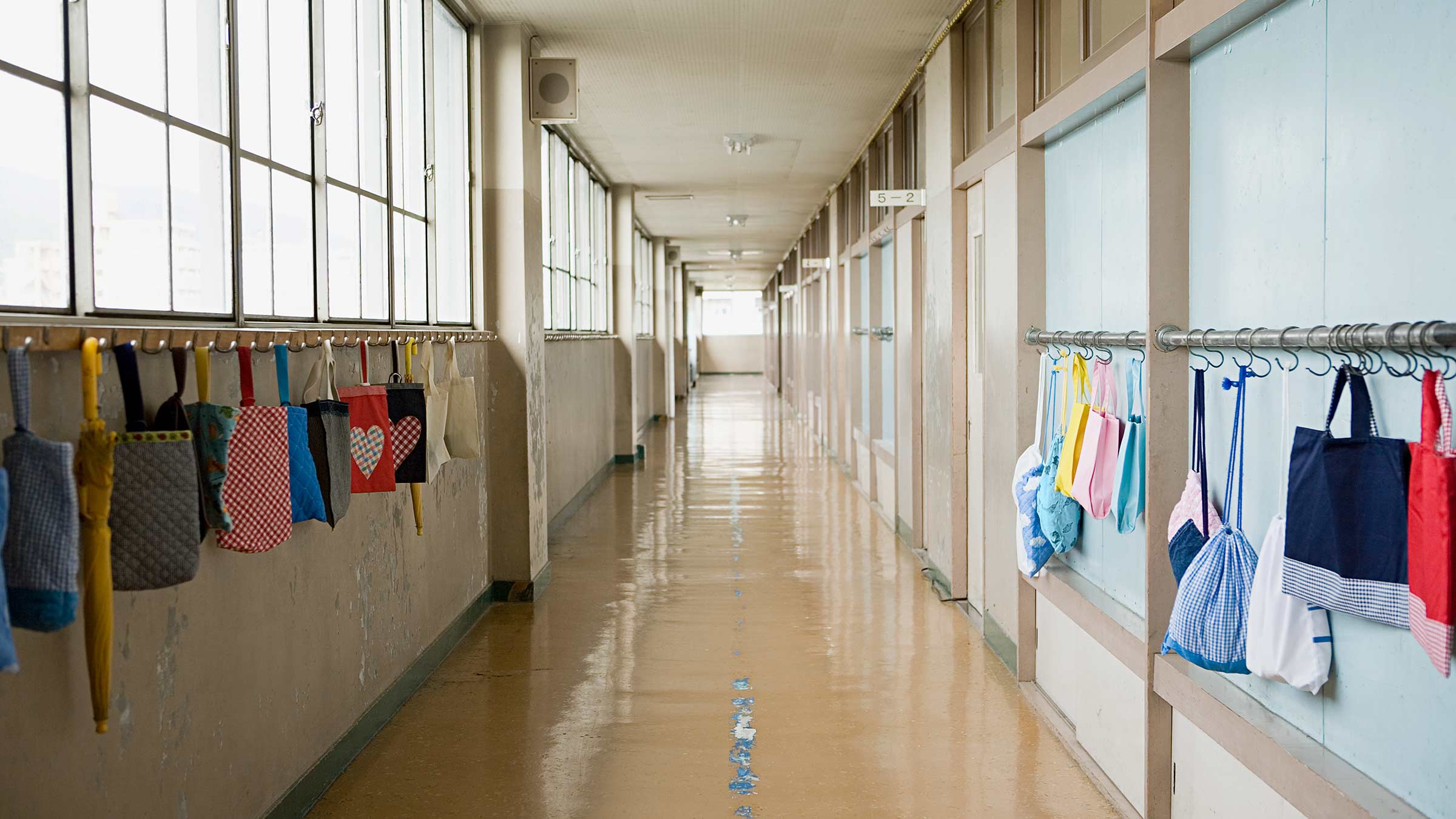 A school corridor with bags hanging along the walls