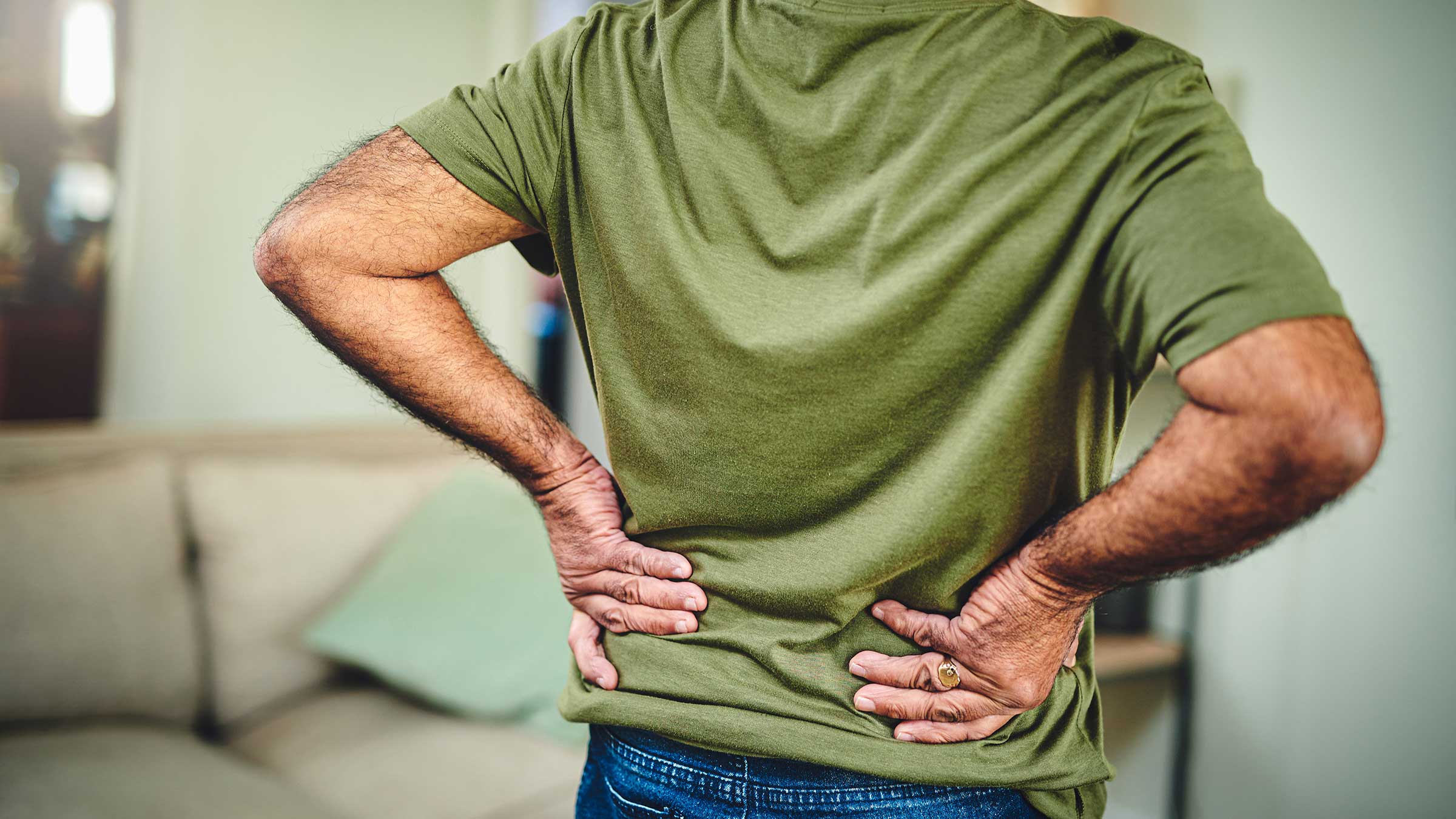 A senior man holding his lower back in pain