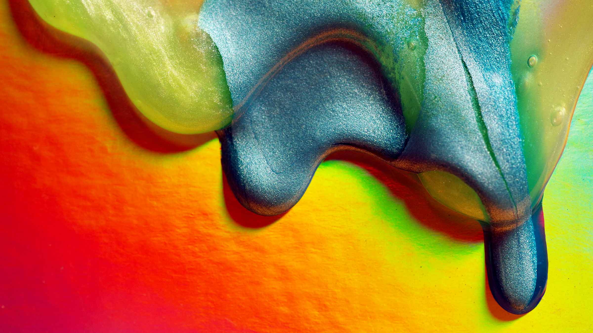 Colorful paint and slime dripping down paper