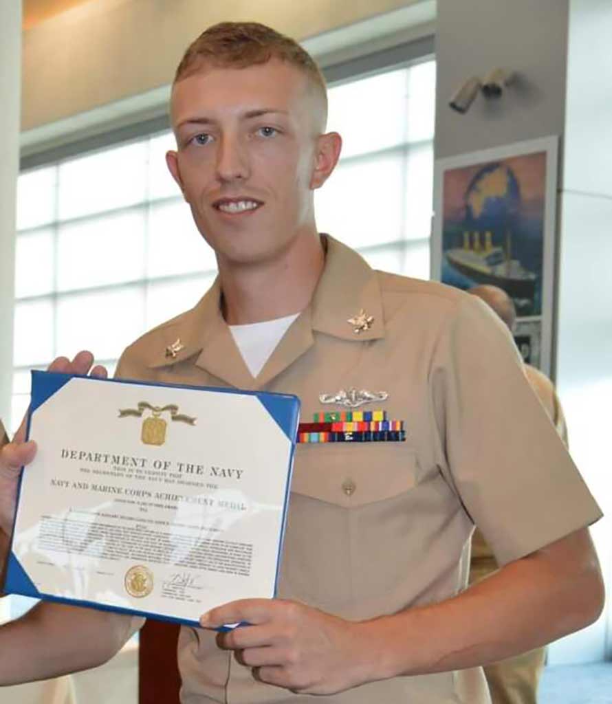 Justin Shupert in his navy uniform receiving an award
