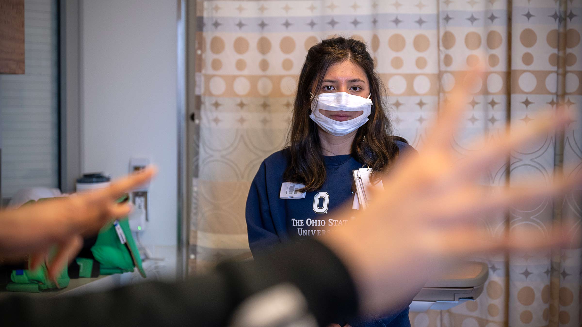 Casey King in the ICU with her interpreter's hand on the foreground