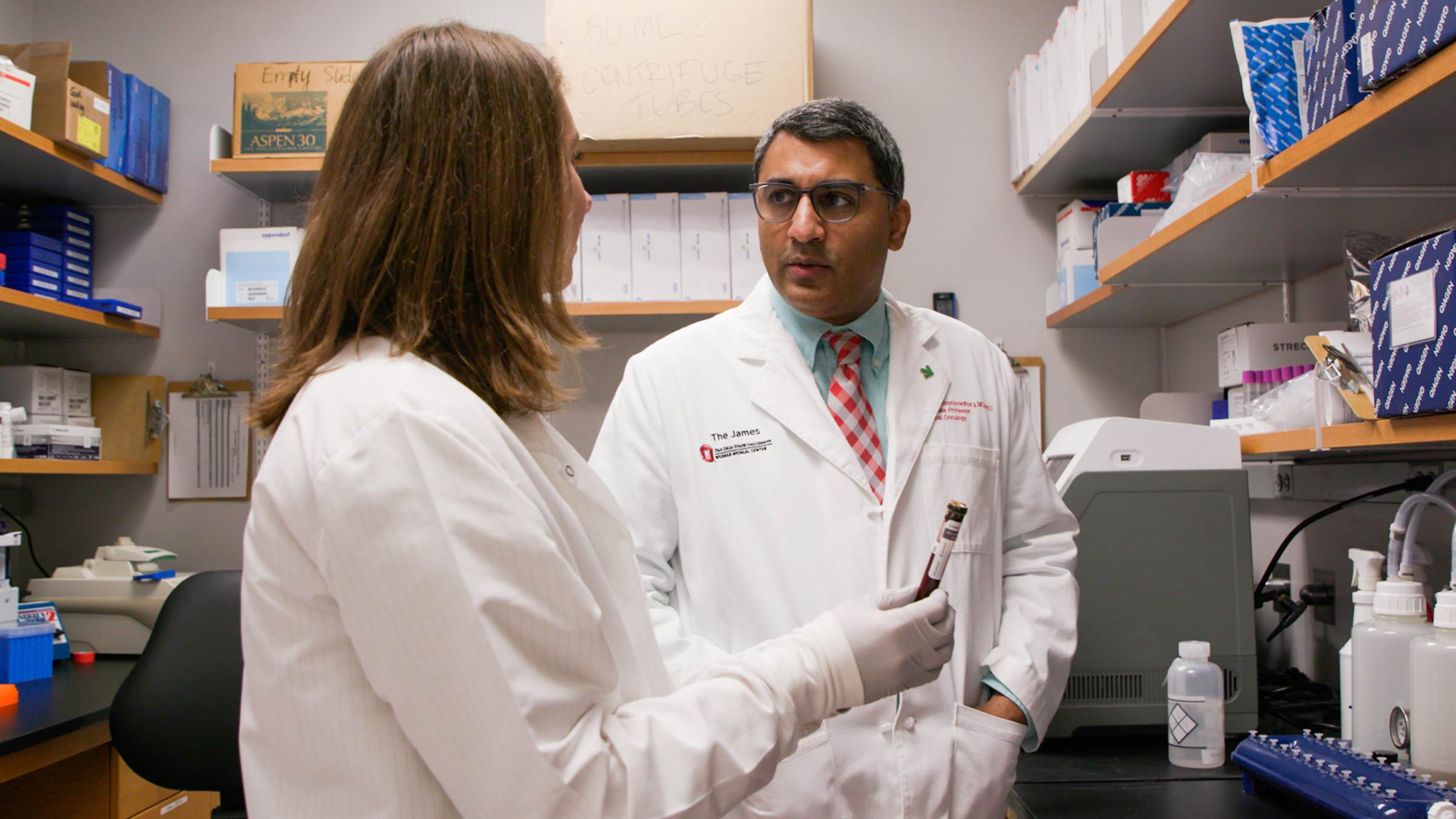 Sameek Roychowdhury, MD, PhD, speaks with a team member while in the laboratory