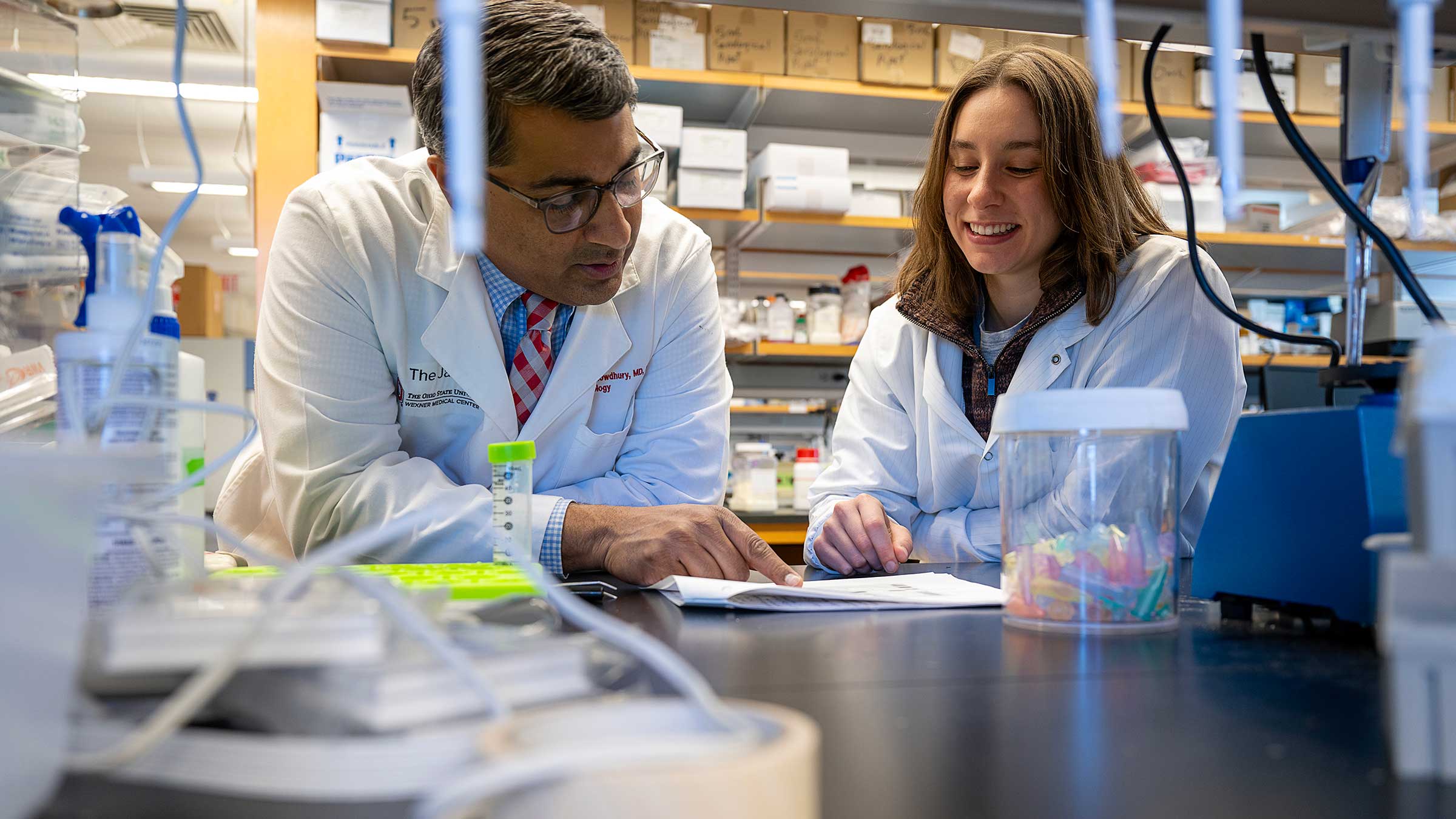 Dr. Roychowdhury talking to a colleague in a lab