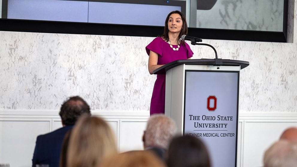 Sarah Anstine behind a podium giving a speech
