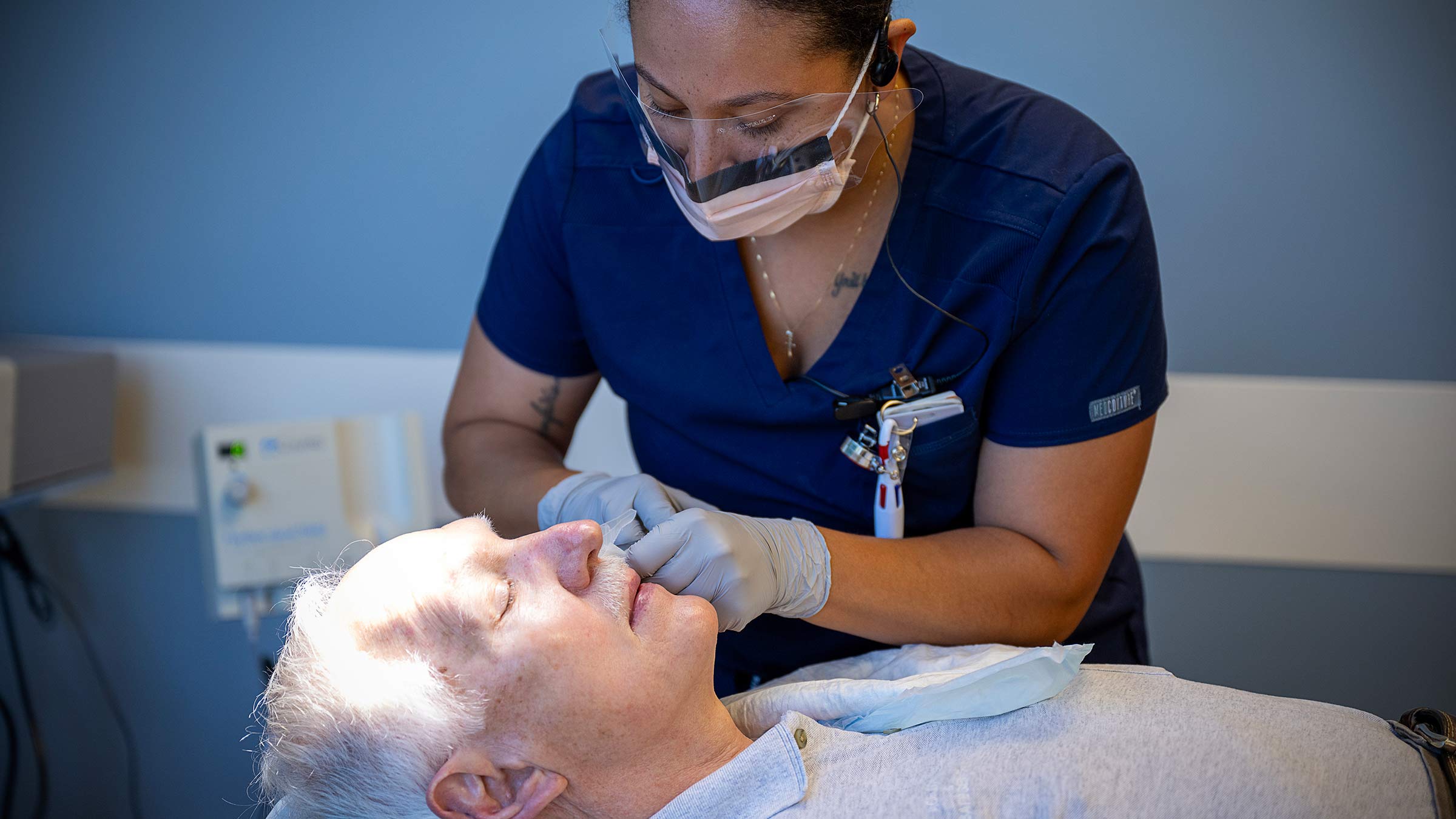 A nurse applying dressings to a patient's face