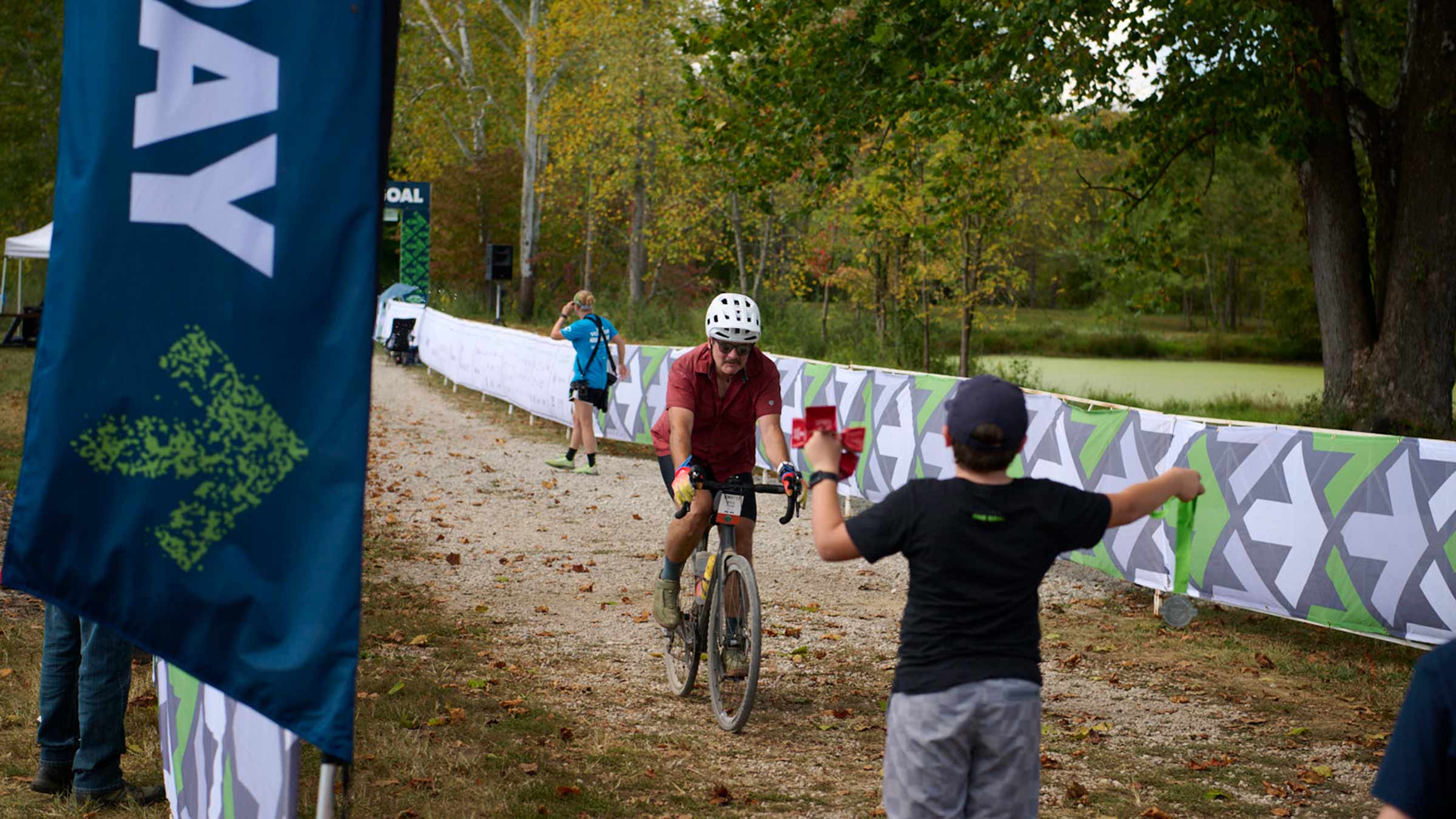 A rider approaching a volunteer who's holding a medal