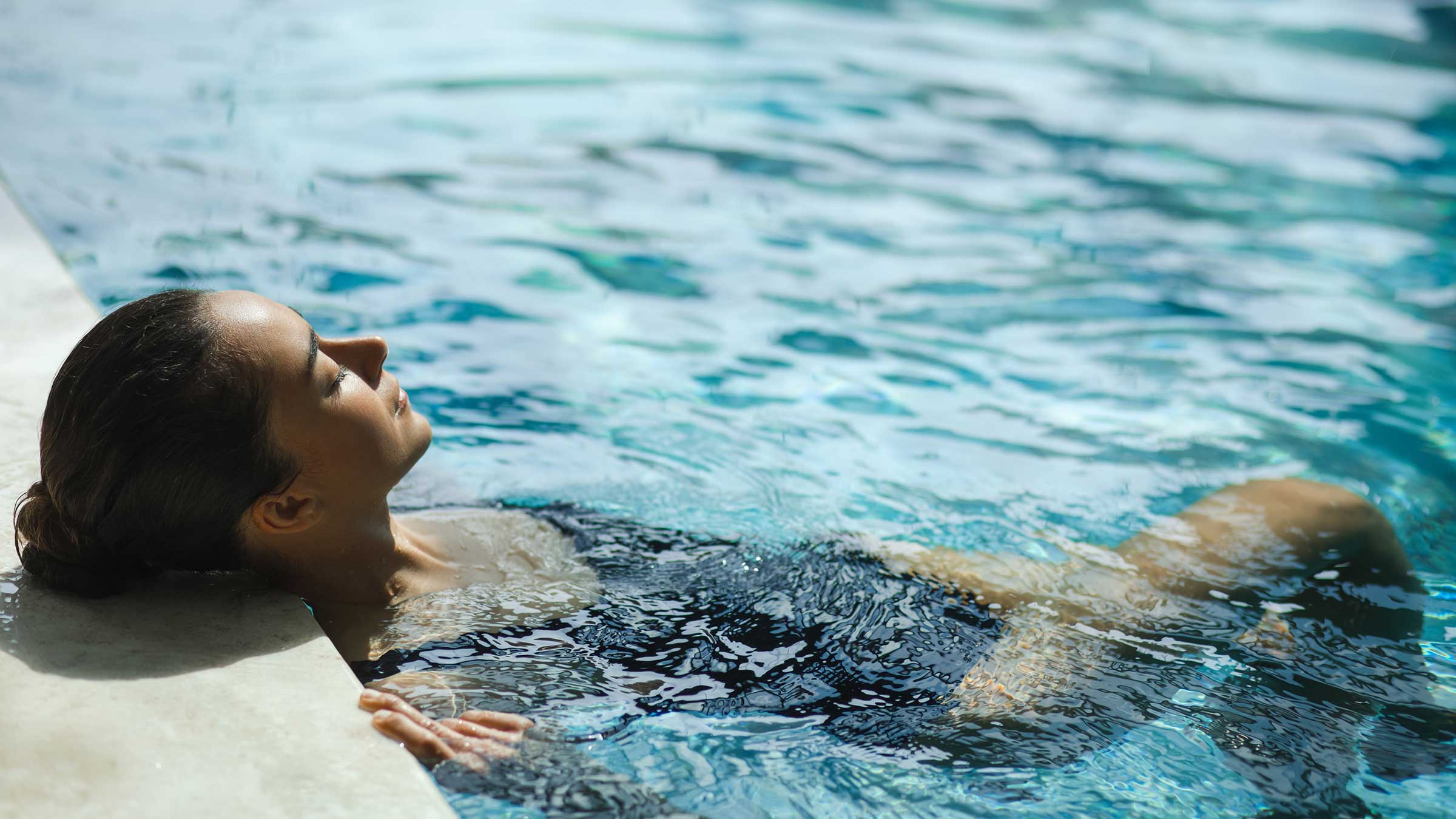 A young woman relaxing in a swimming pool