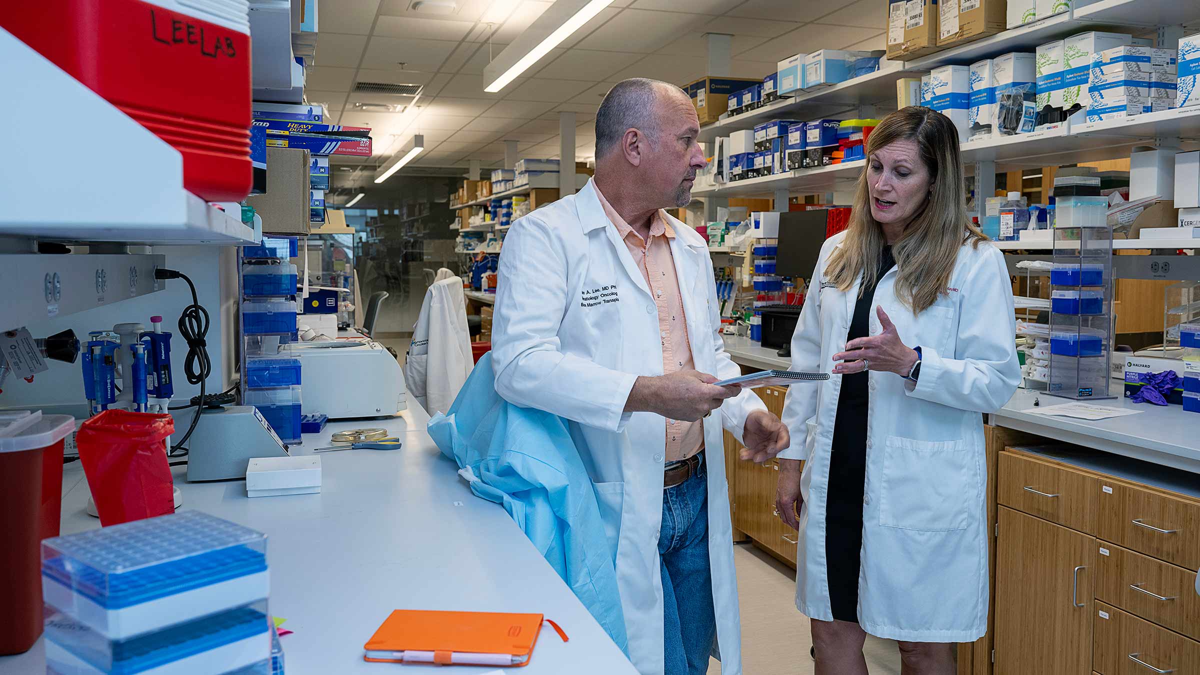 Dr. Gatti-Mays talking to Dr. Lee in the lab