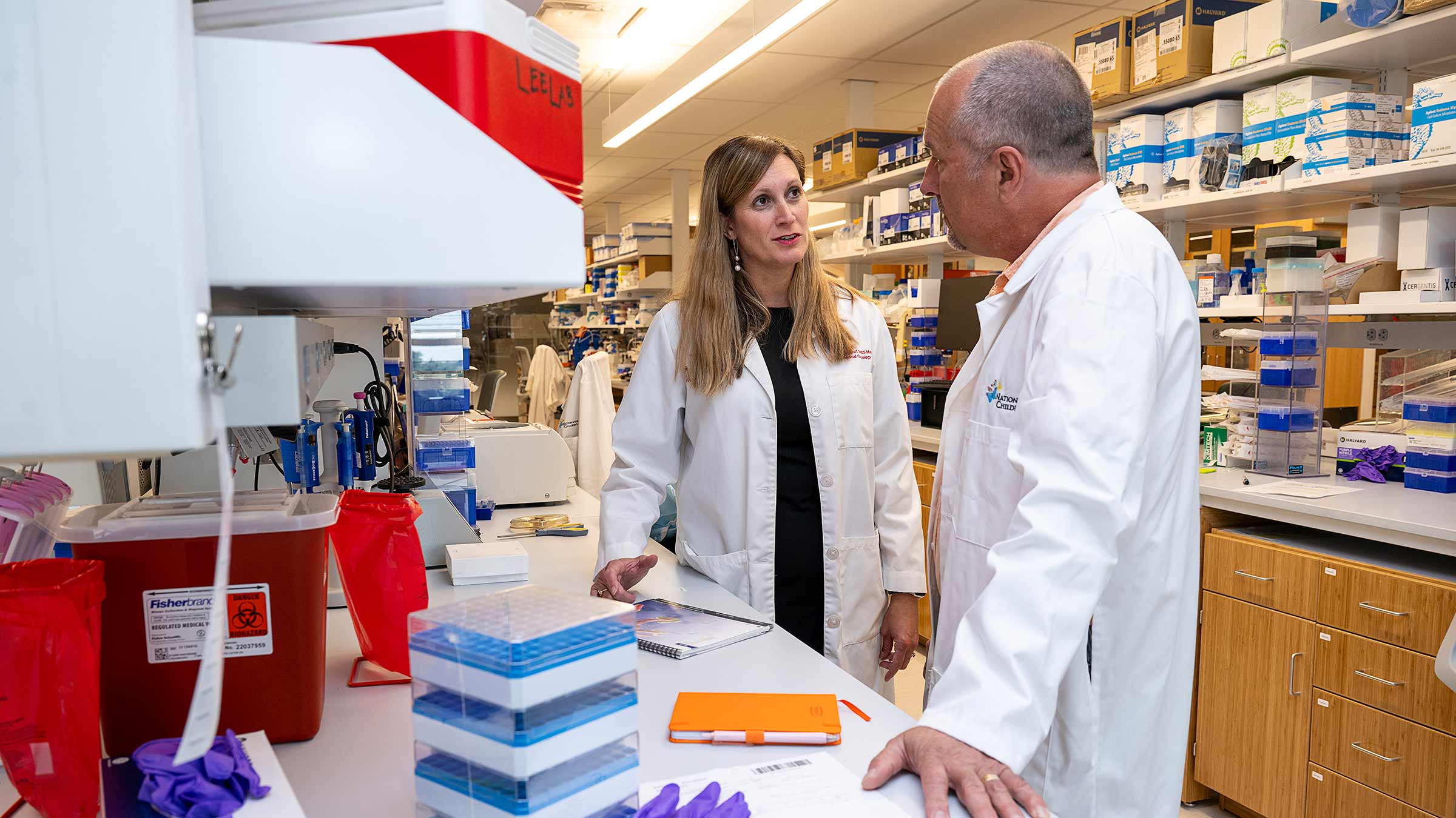 Dr. Gatti-Mays talking to Dr. Lee in the lab