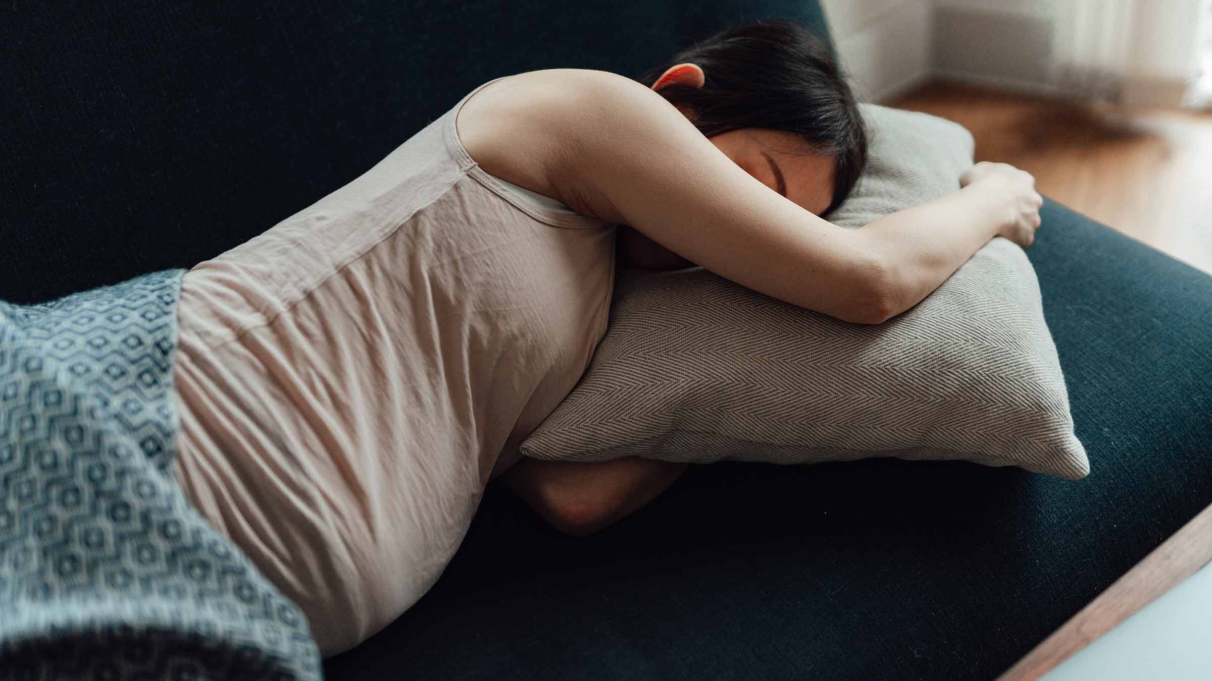 Young Asian pregnant woman sleeping on a sofa