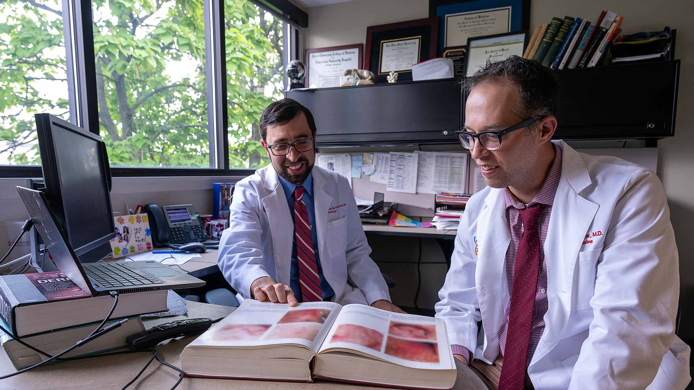 Dermatologists Abraham Korman and Benjamin Kaffenberger reading a book on skin conditions