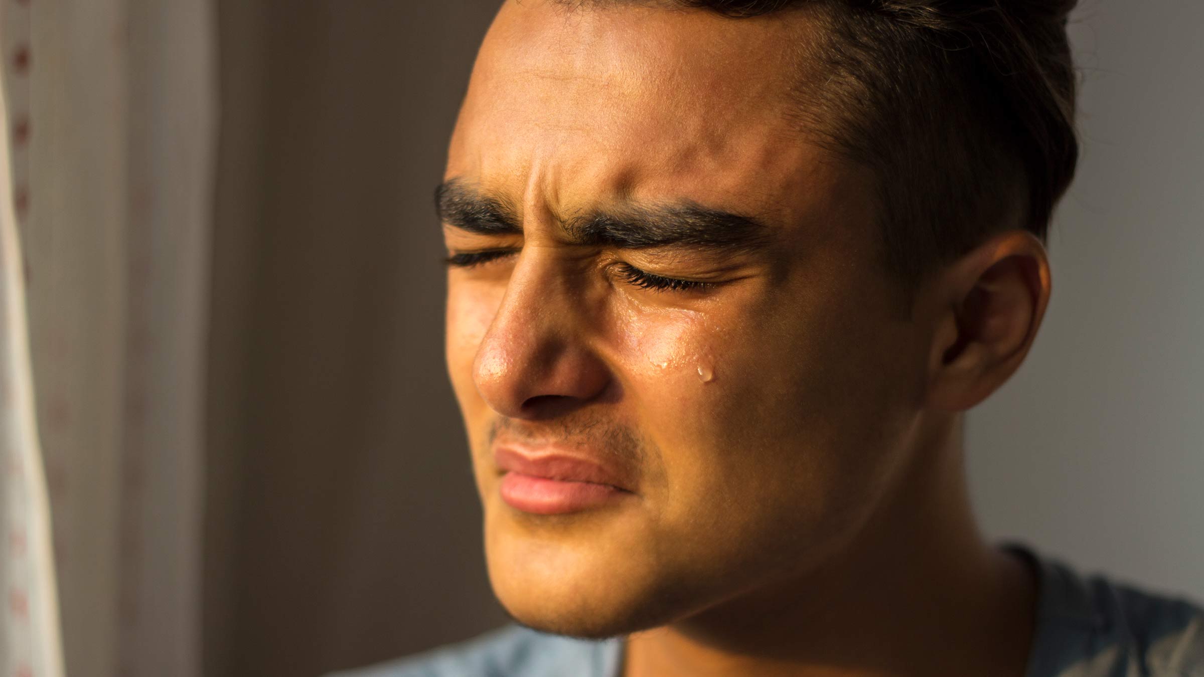 Young man with tears running down his cheek