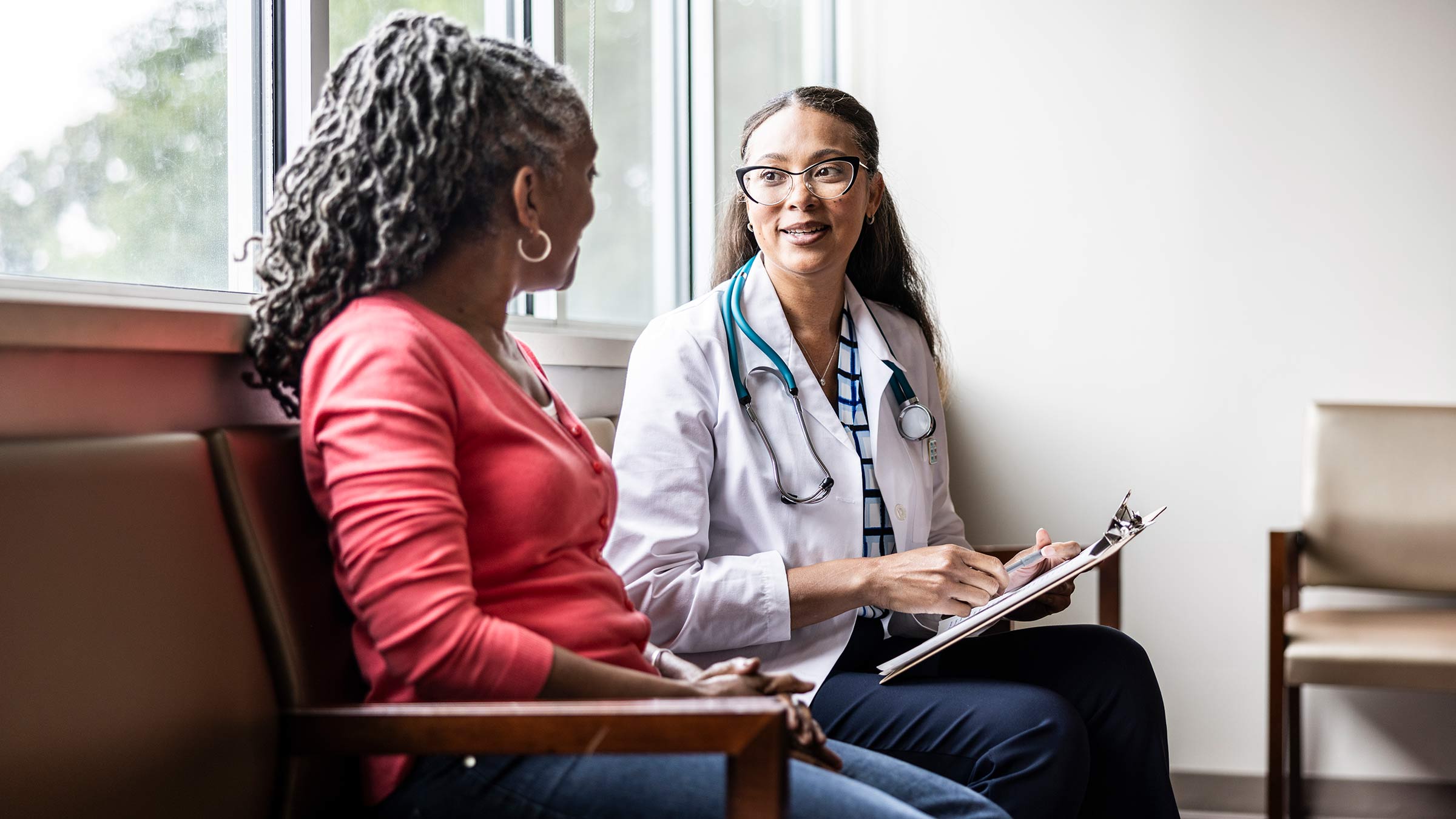 Female doctor speaking with a senior African American woman in a medical office