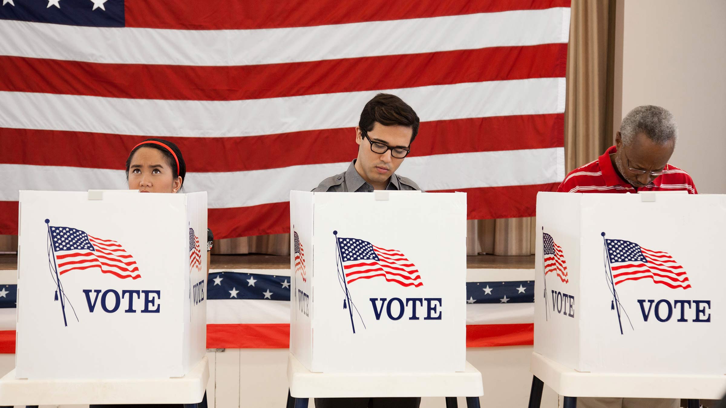 Three people voting at the polls on election day