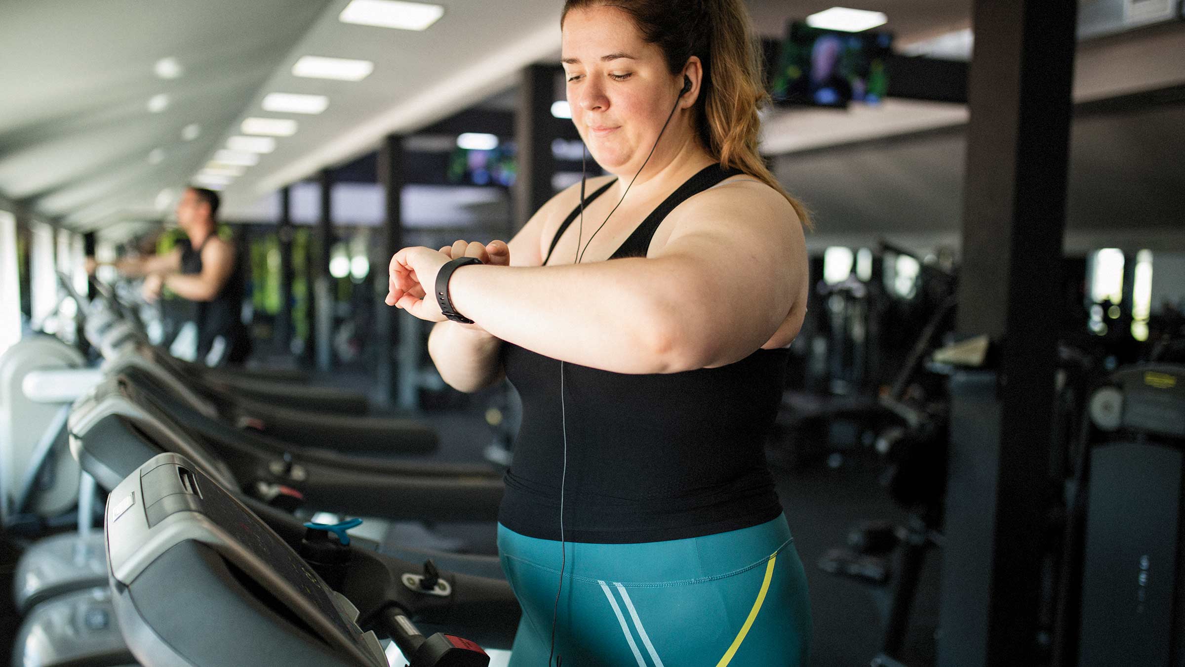 A woman walking on a treadmill in a gym