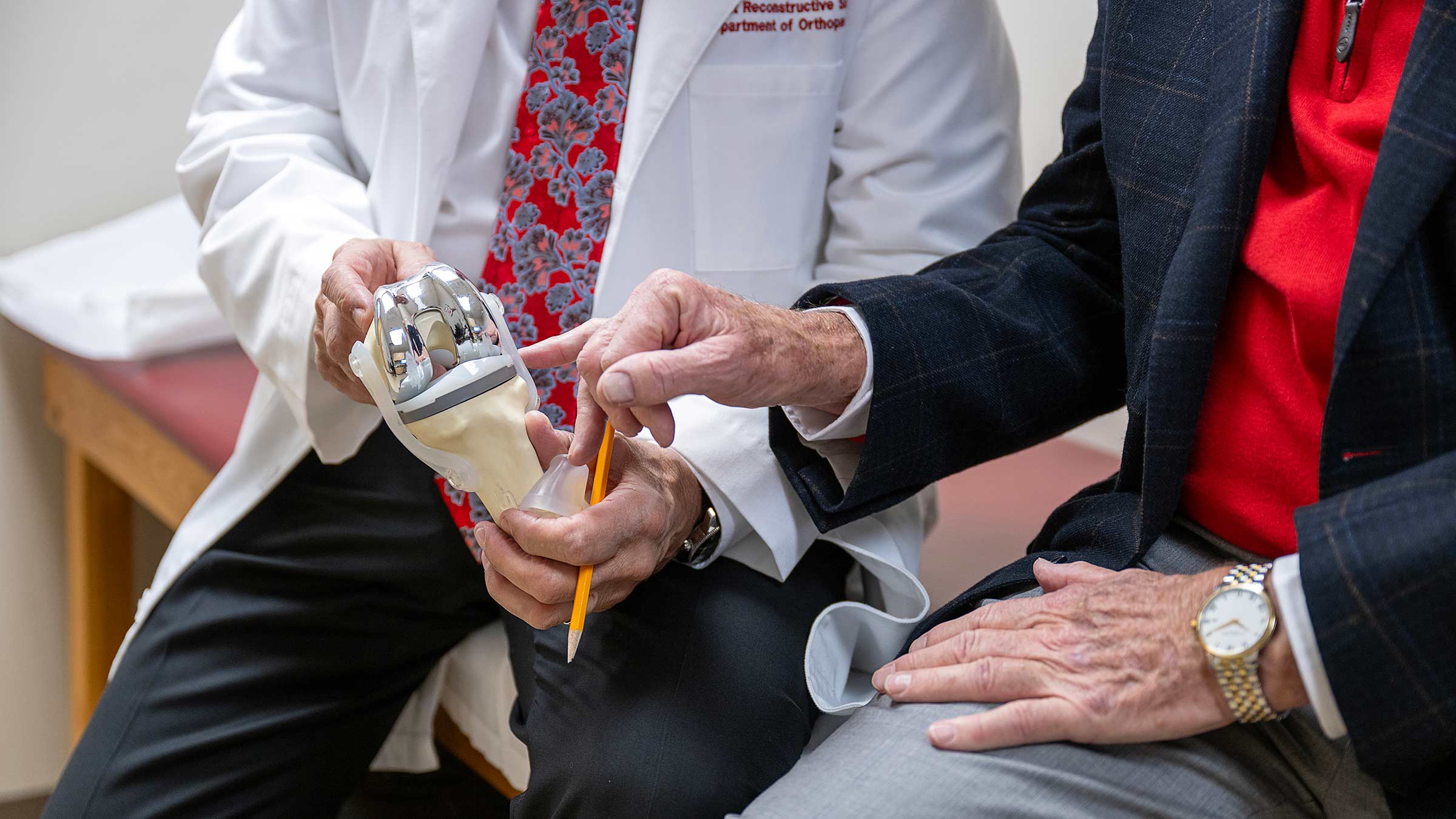 A closeup image of Dr. Andrew Glassman demonstrating joint function with an artificial joint