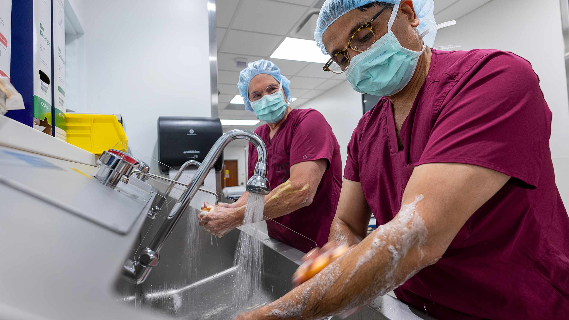 Doctors wash their hands and forearms before the surgery