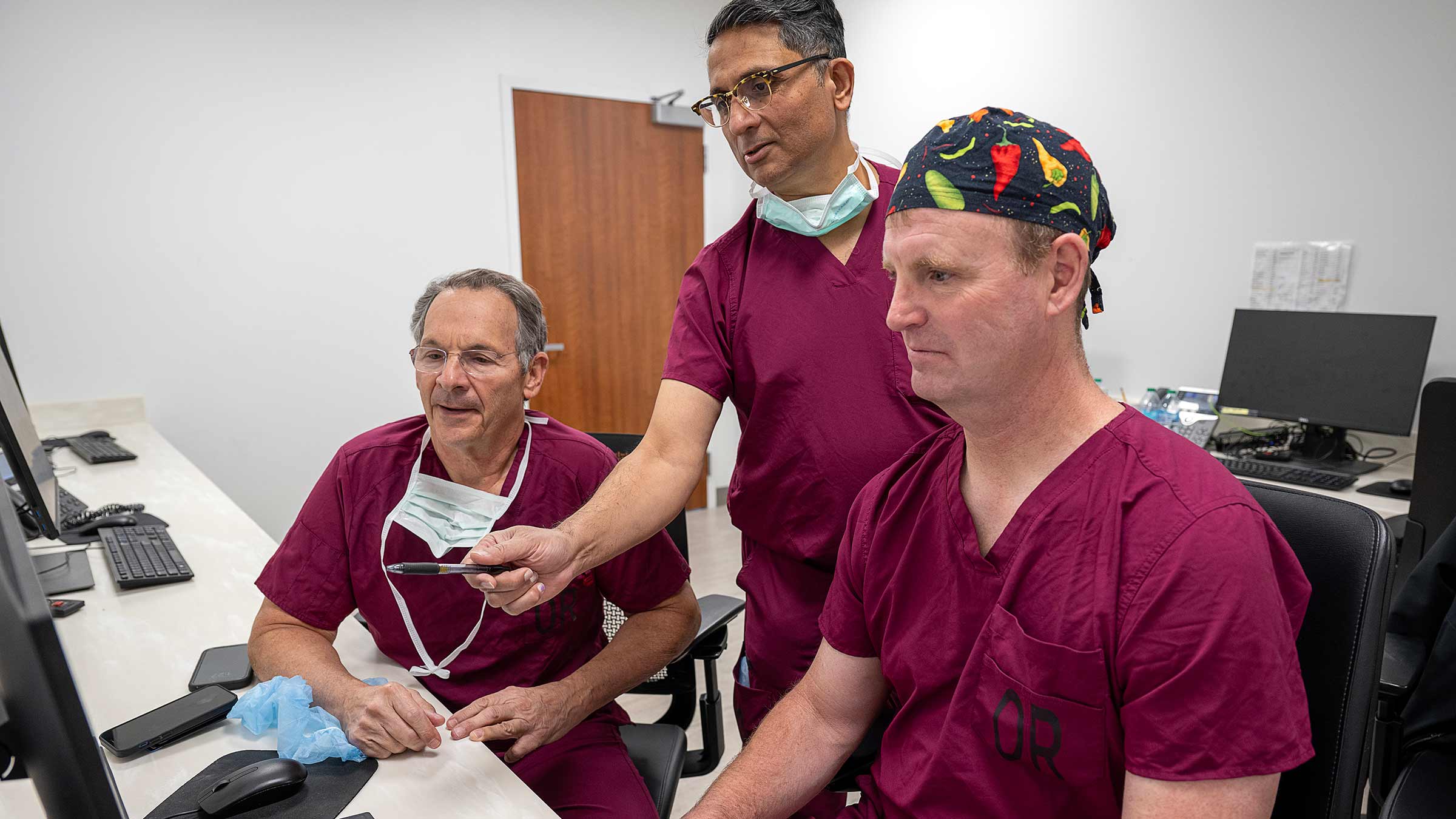 Dr. Glassman and his colleagues talk while looking at the computer