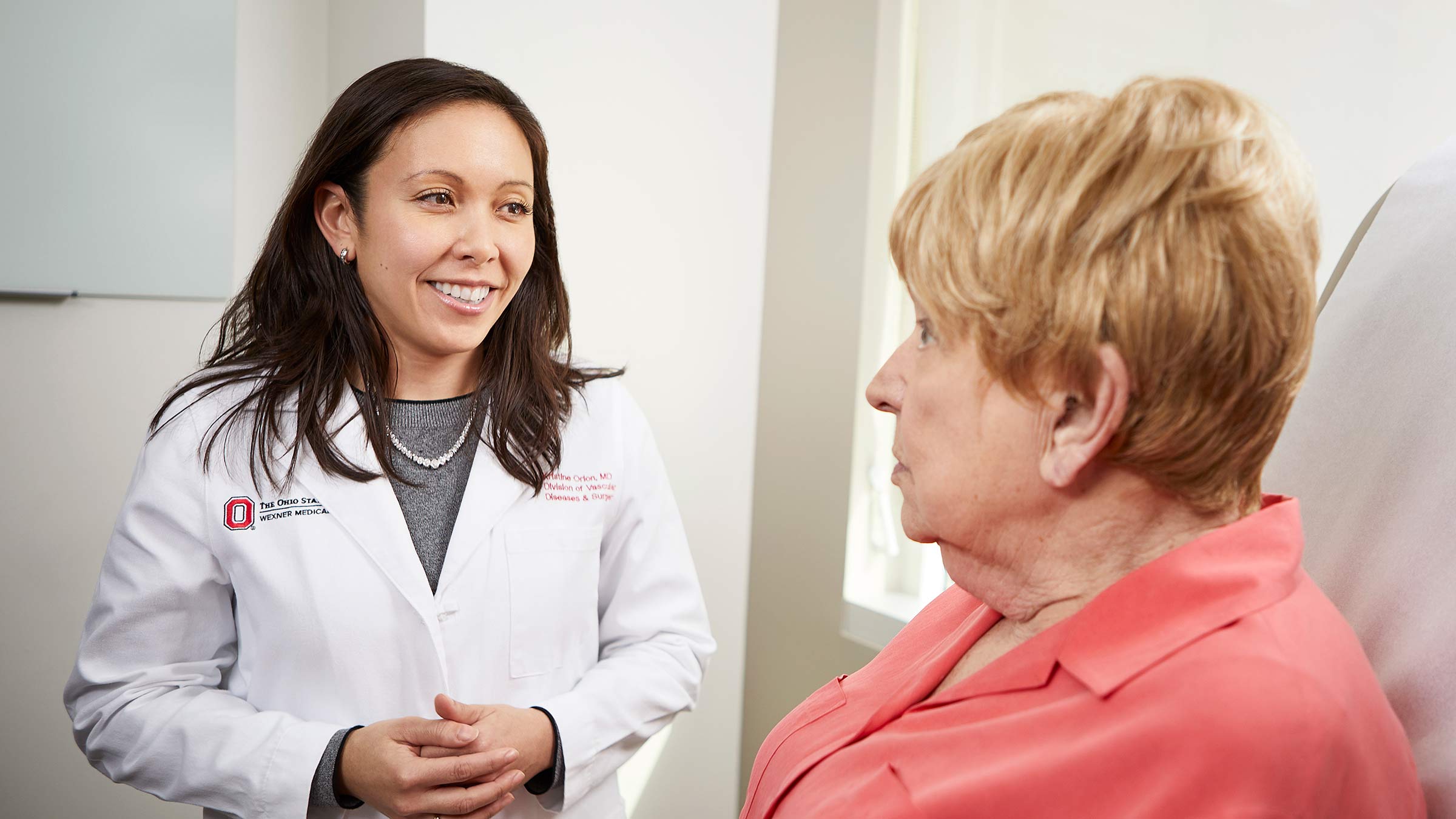Dr. Kristine Orion consulting with a patient in her medical uniform