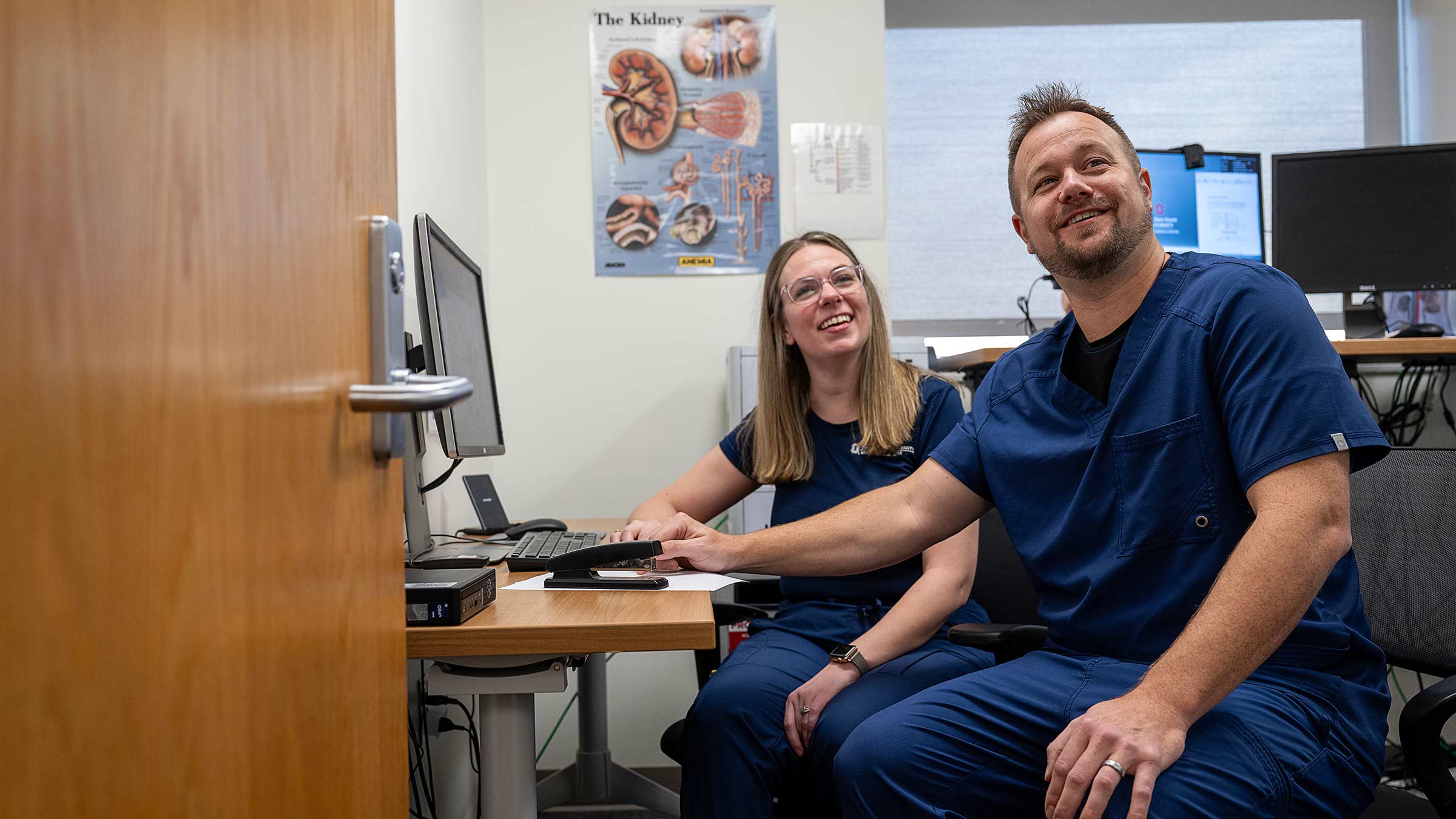 Transplant coordinators Mike Lange and Grace Gray reviewing the kidney transplant waitlist