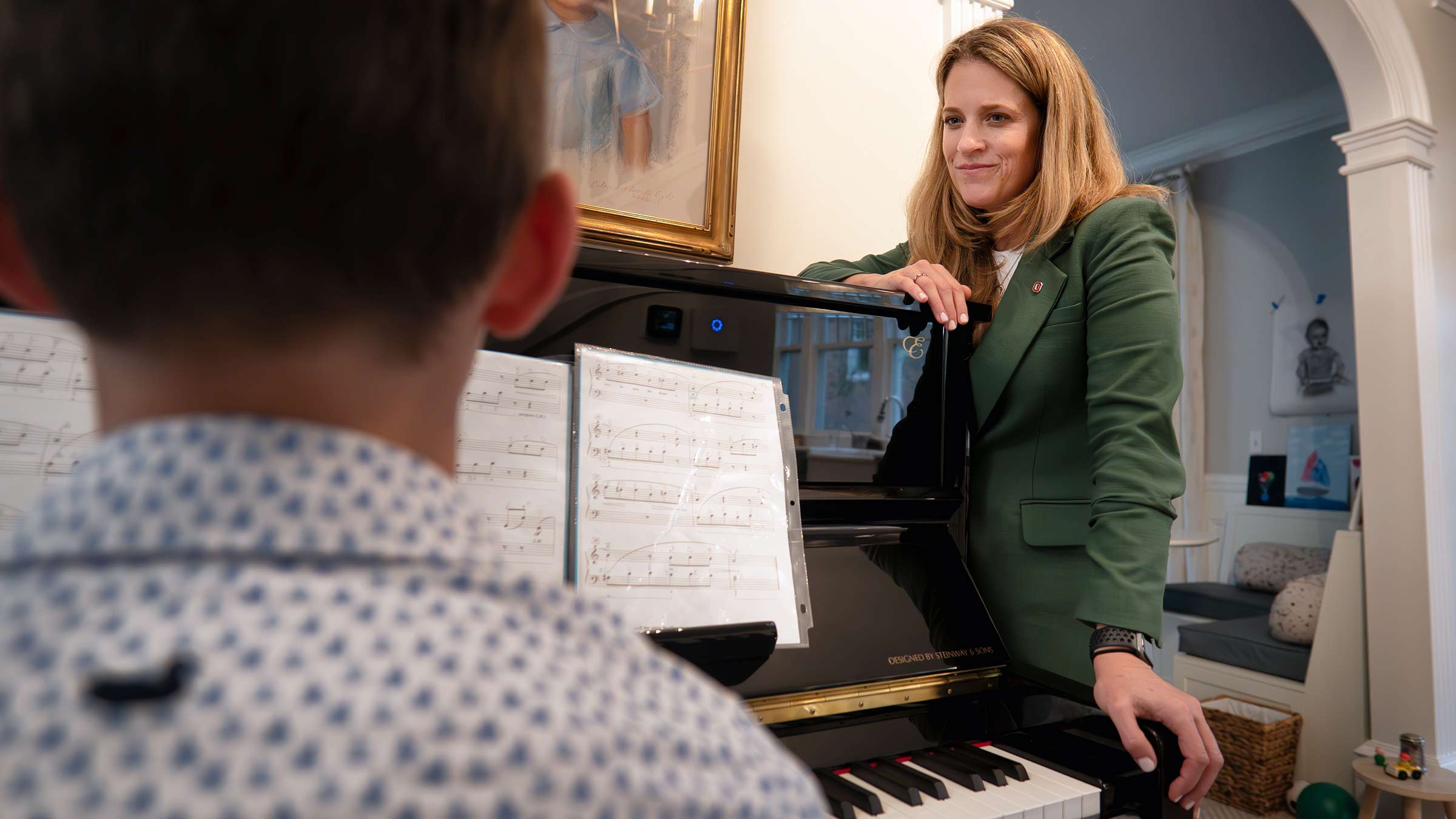 Dr. Amy Moore looking at Byron sitting in front of the piano