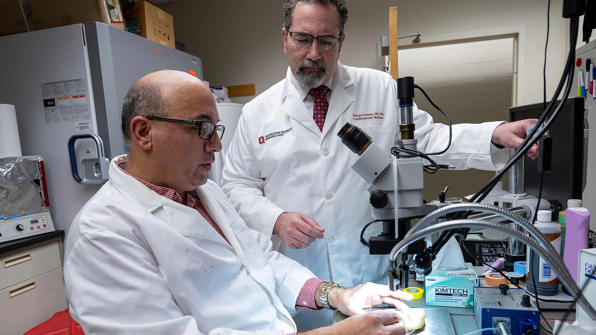 Dr. Gumina with a colleague next to a microscope