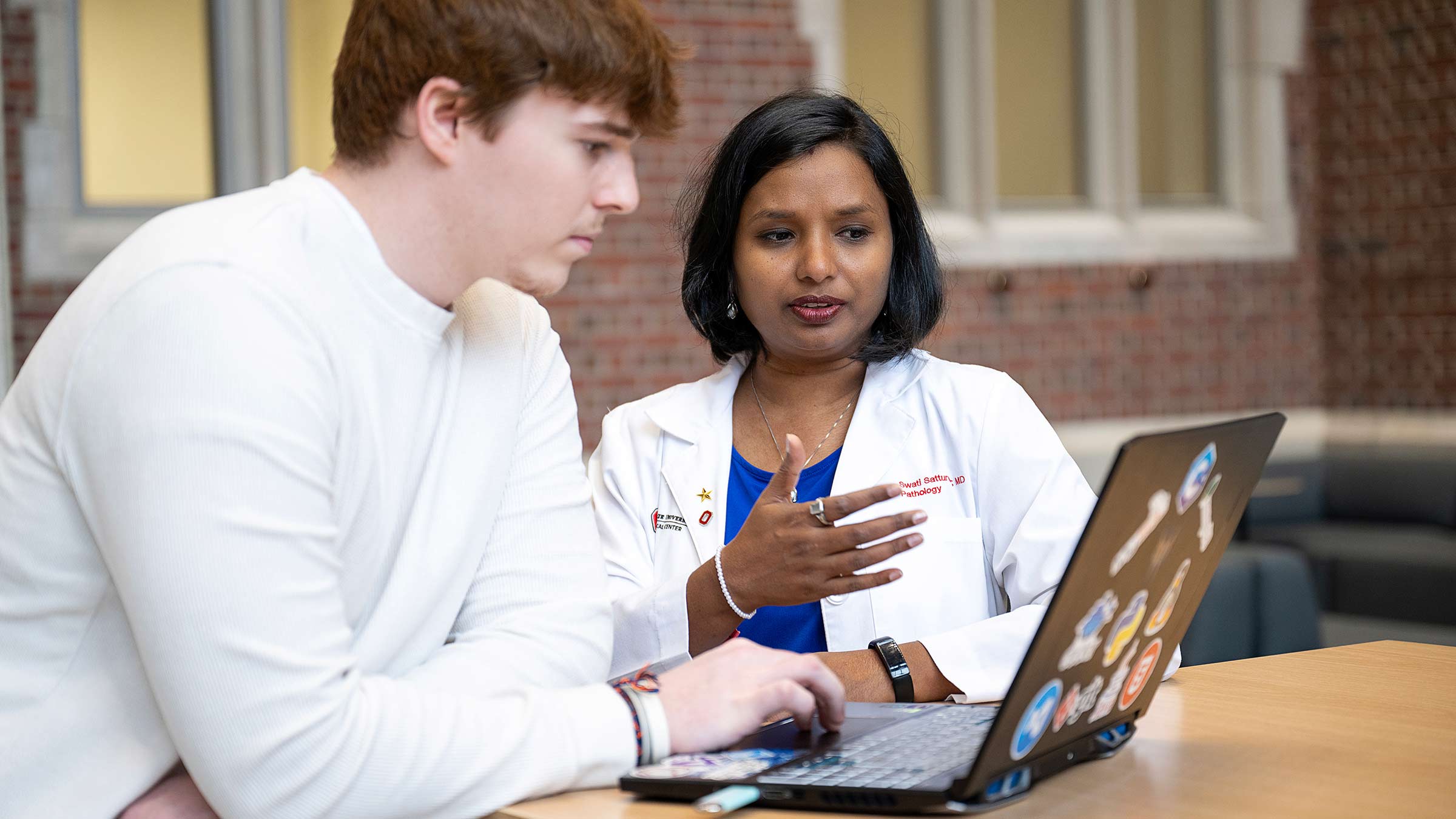 Appathon students conversing while looking at a laptop computer