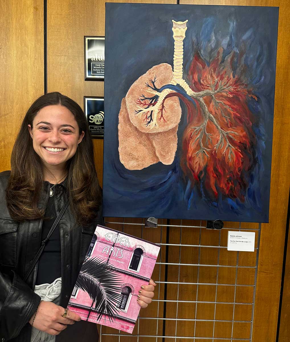 Natalie Brillhart next to her painting of lungs