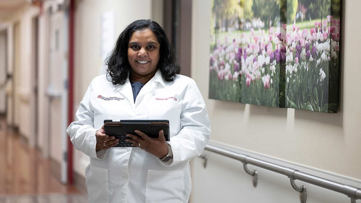 Dr. Sheital Bavishi in her medical uniform with a tablet