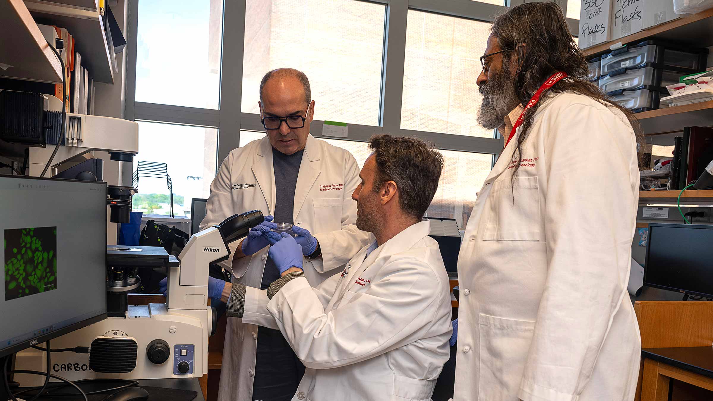 Dr. Christian Rolfo viewing a petri dish with his colleagues