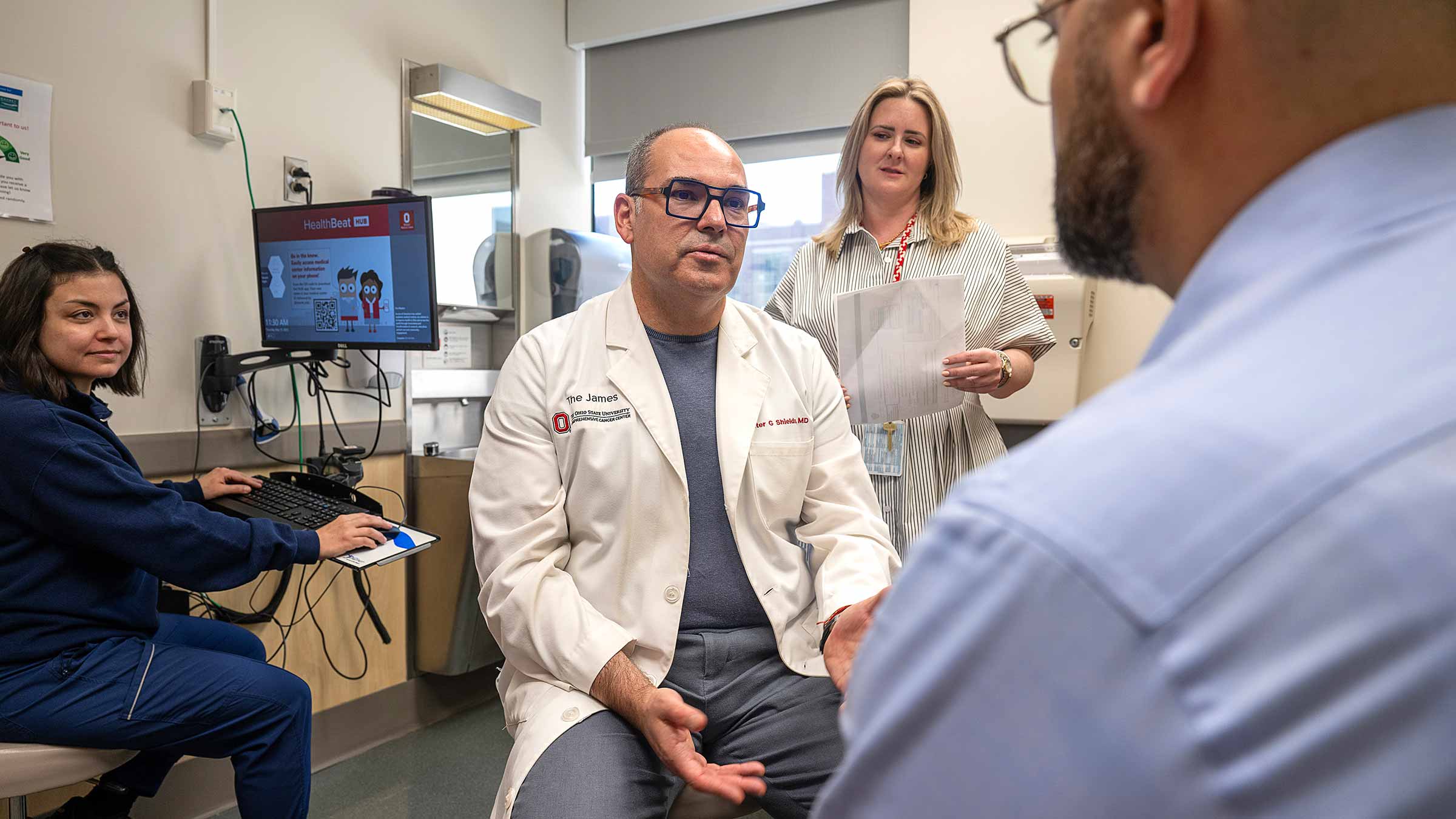 Dr. Christian Rolfo and his associates speaking with a patient
