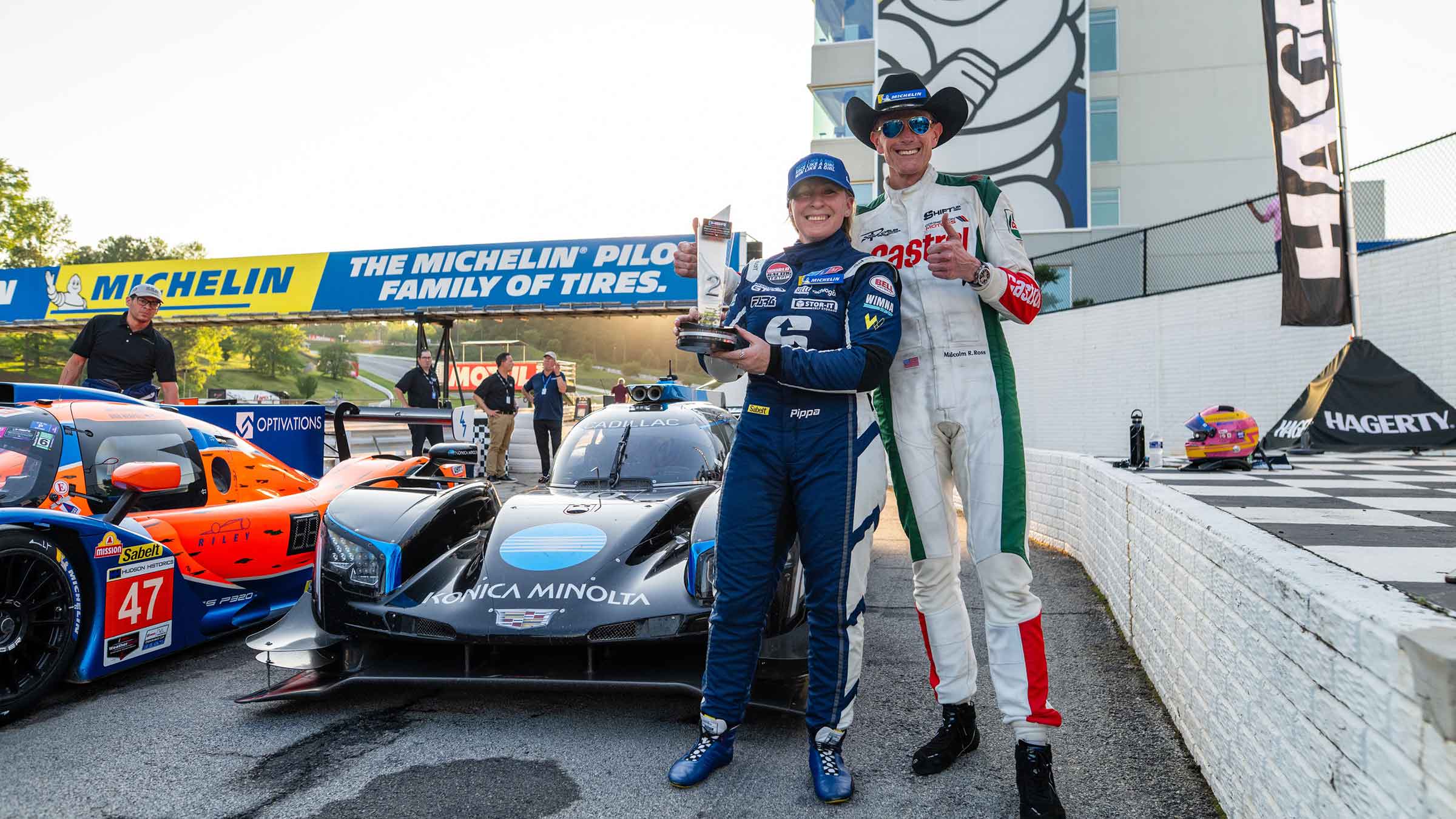 Malcolm Ross standing next to Pippa Mann at a race track