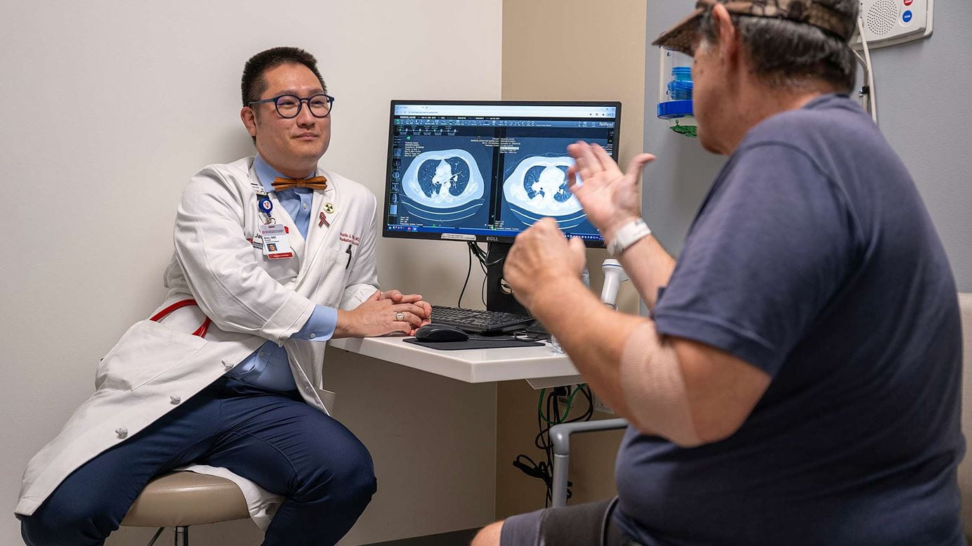 Mike Penrod talking to a doctor pointing to a scan on a screen