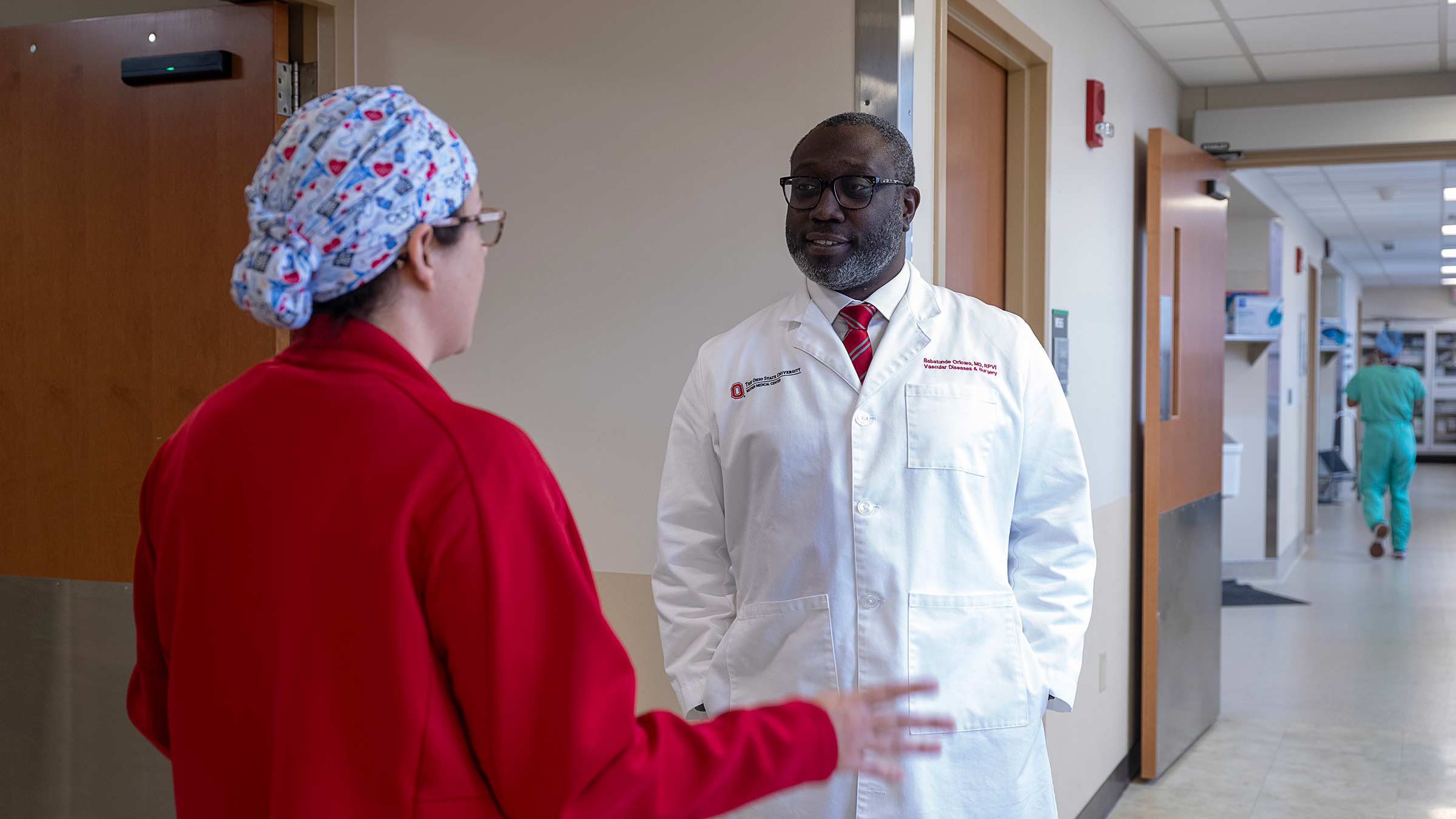 Dr. Oriowo talks with a nurse in a hospital hallway