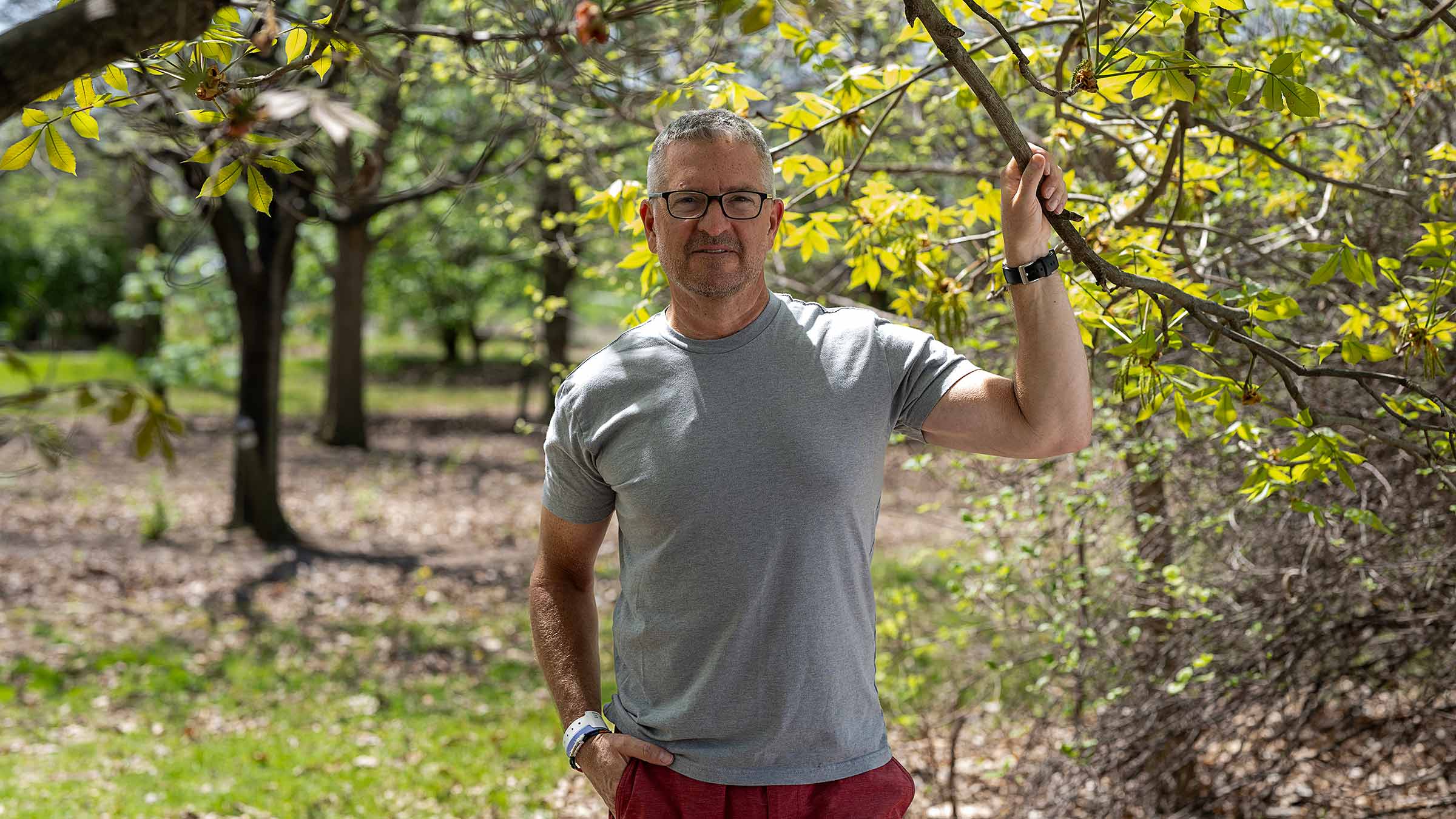 Brian Bognar standing outside among the trees