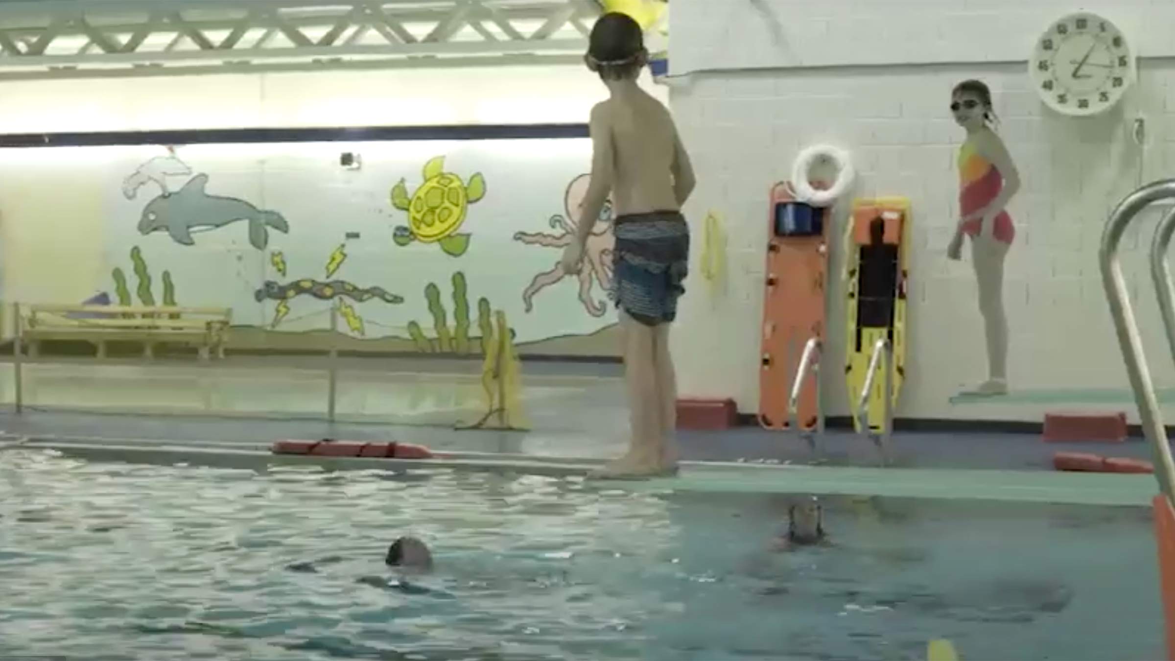 Kids getting ready to jump into the pool during a swim class