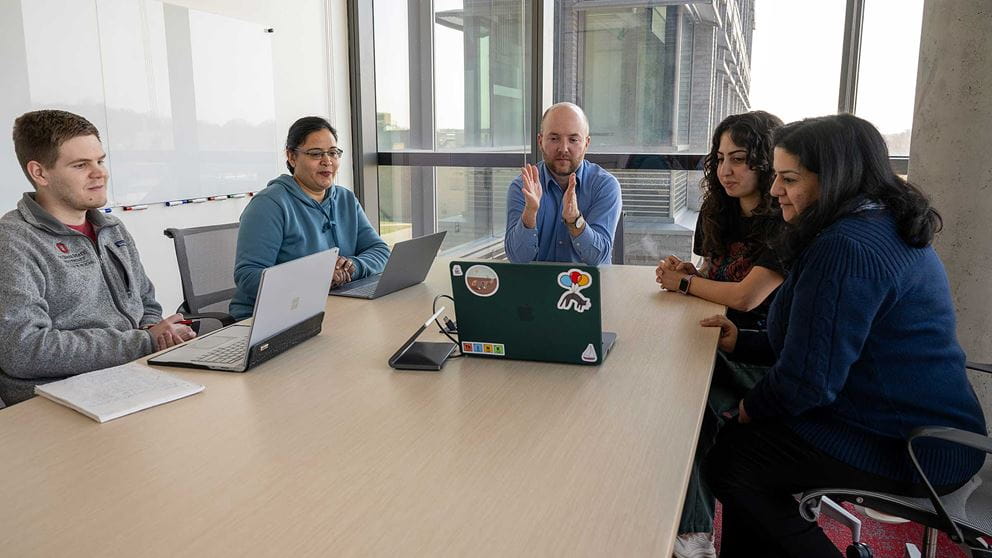 Dr. Thomas Mendel in a conference room with colleagues