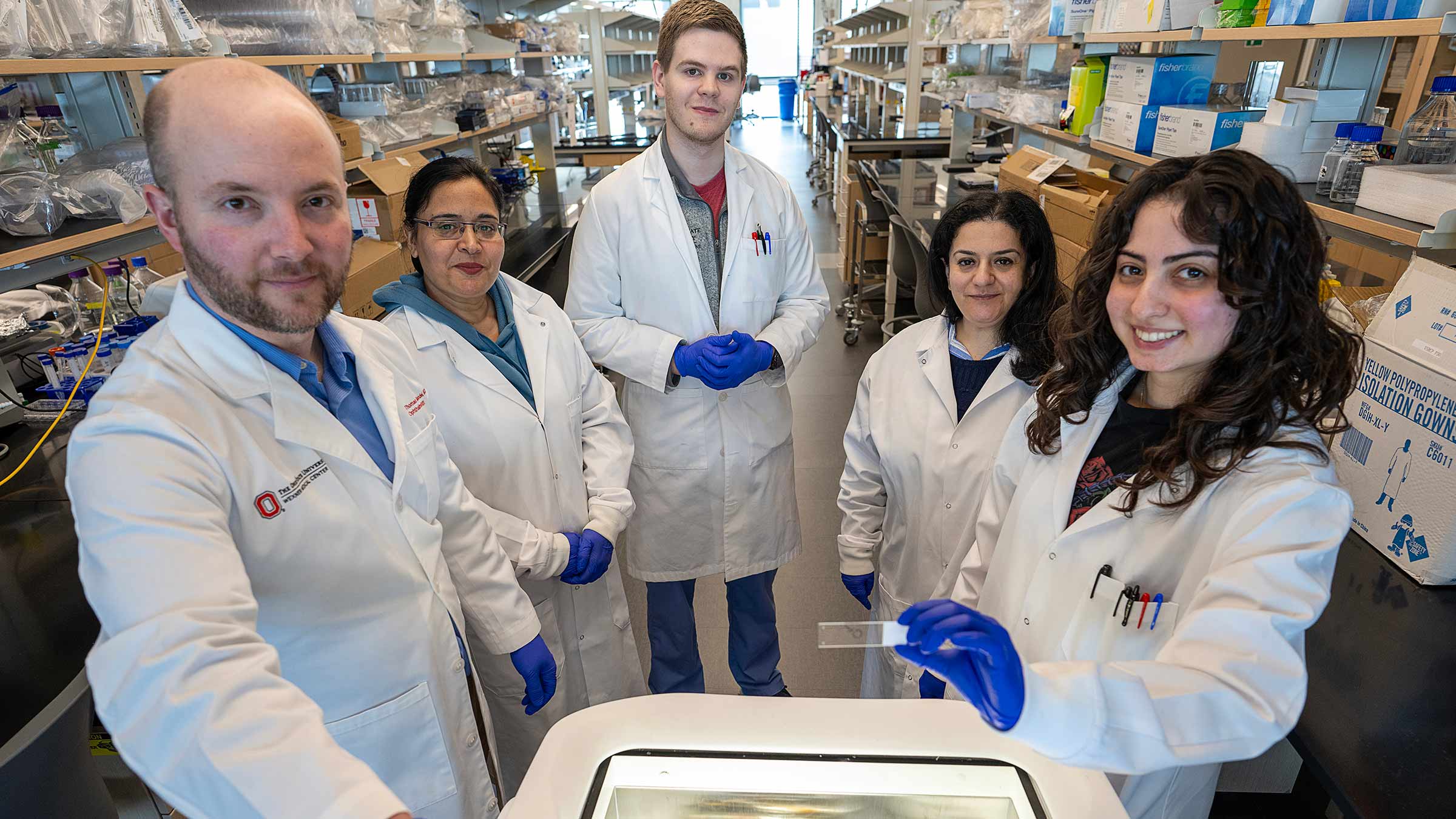 Dr. Thomas Mendel and his colleagues in lab coats in a research facility