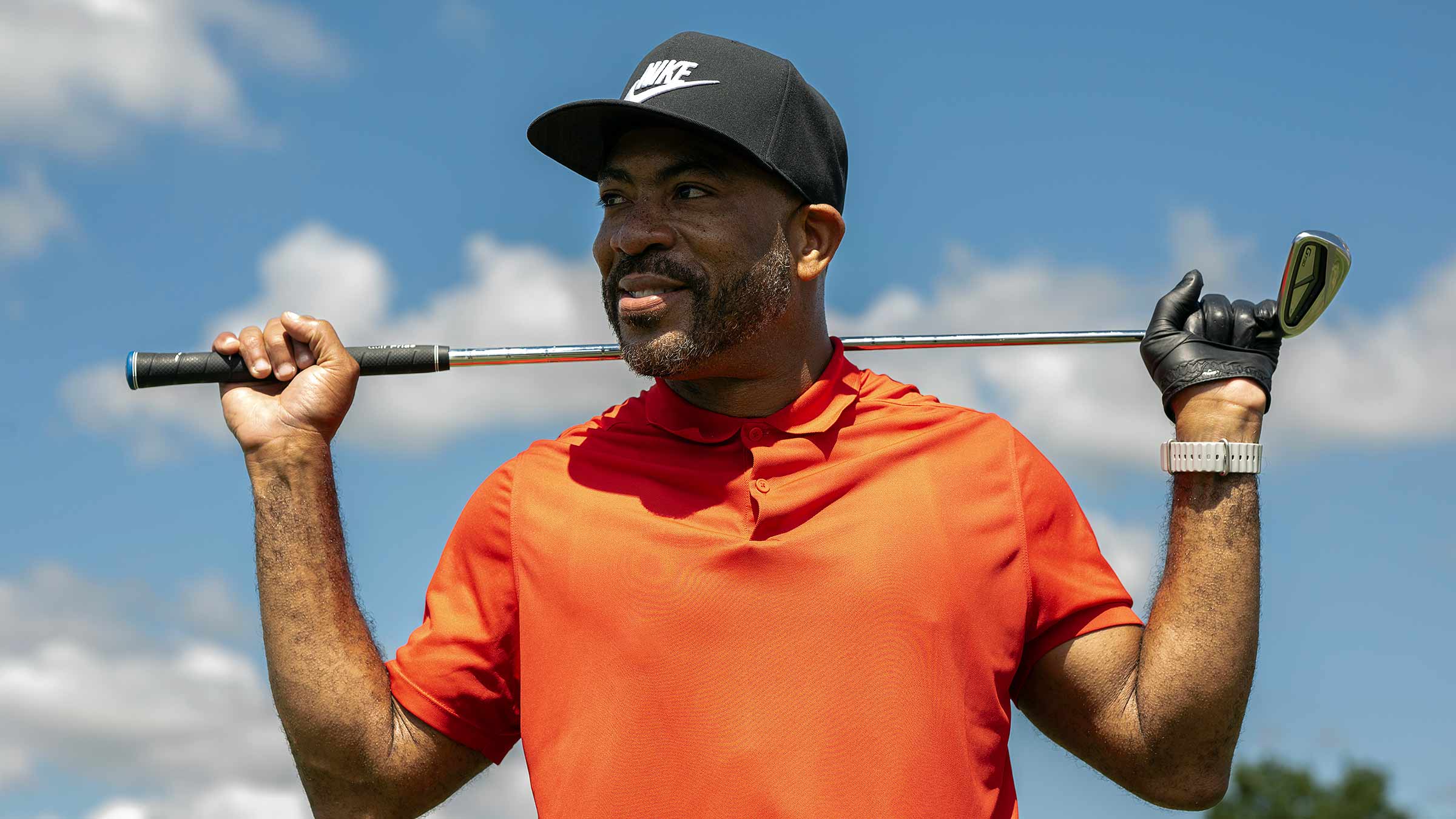 Patient Dee Miller holding a golf club over his shoulders