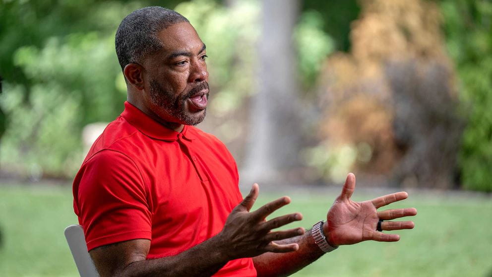 Patient Dee Miller sitting on a lawn chair at his home