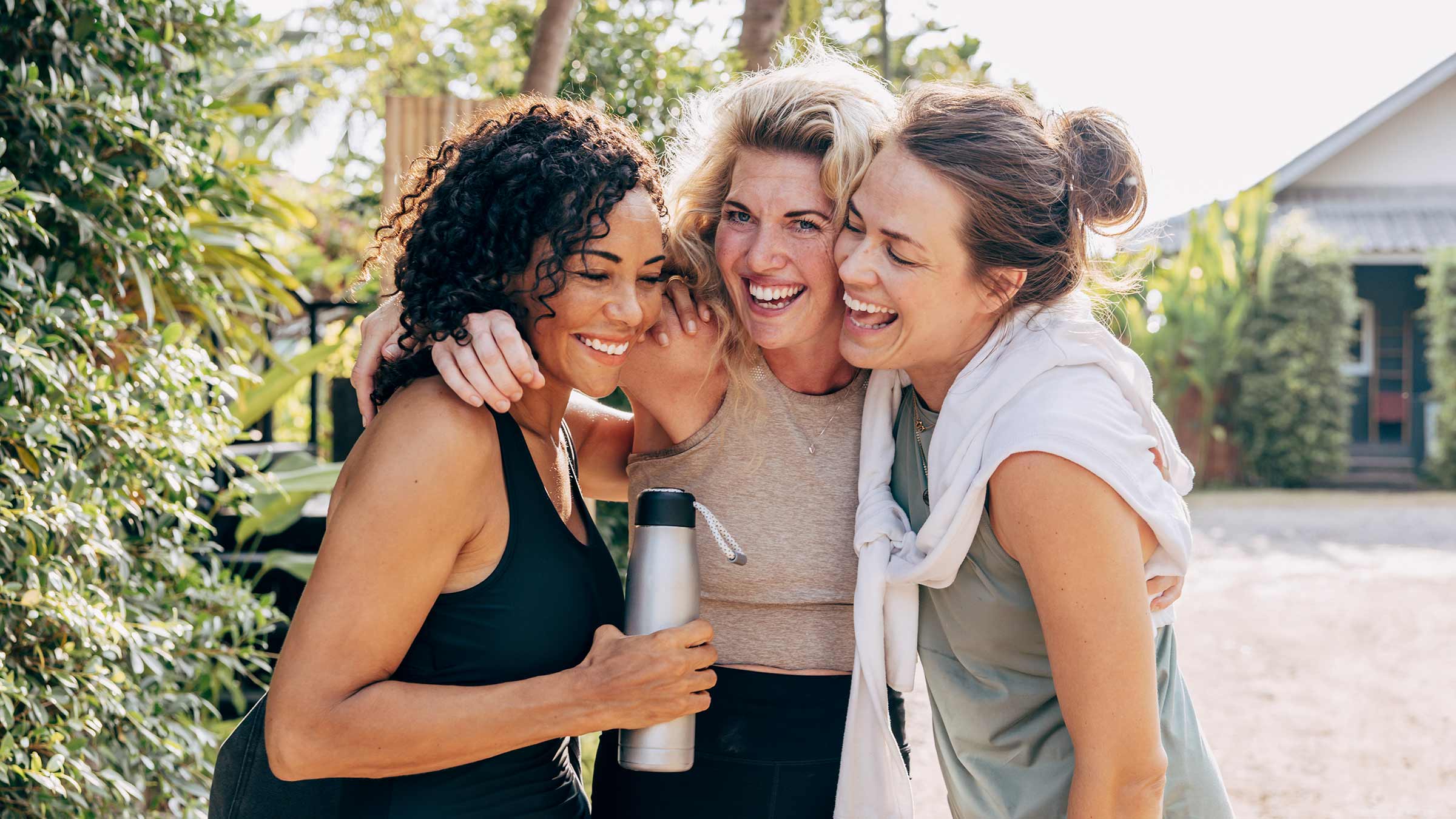 Three women hugging each other and laughing