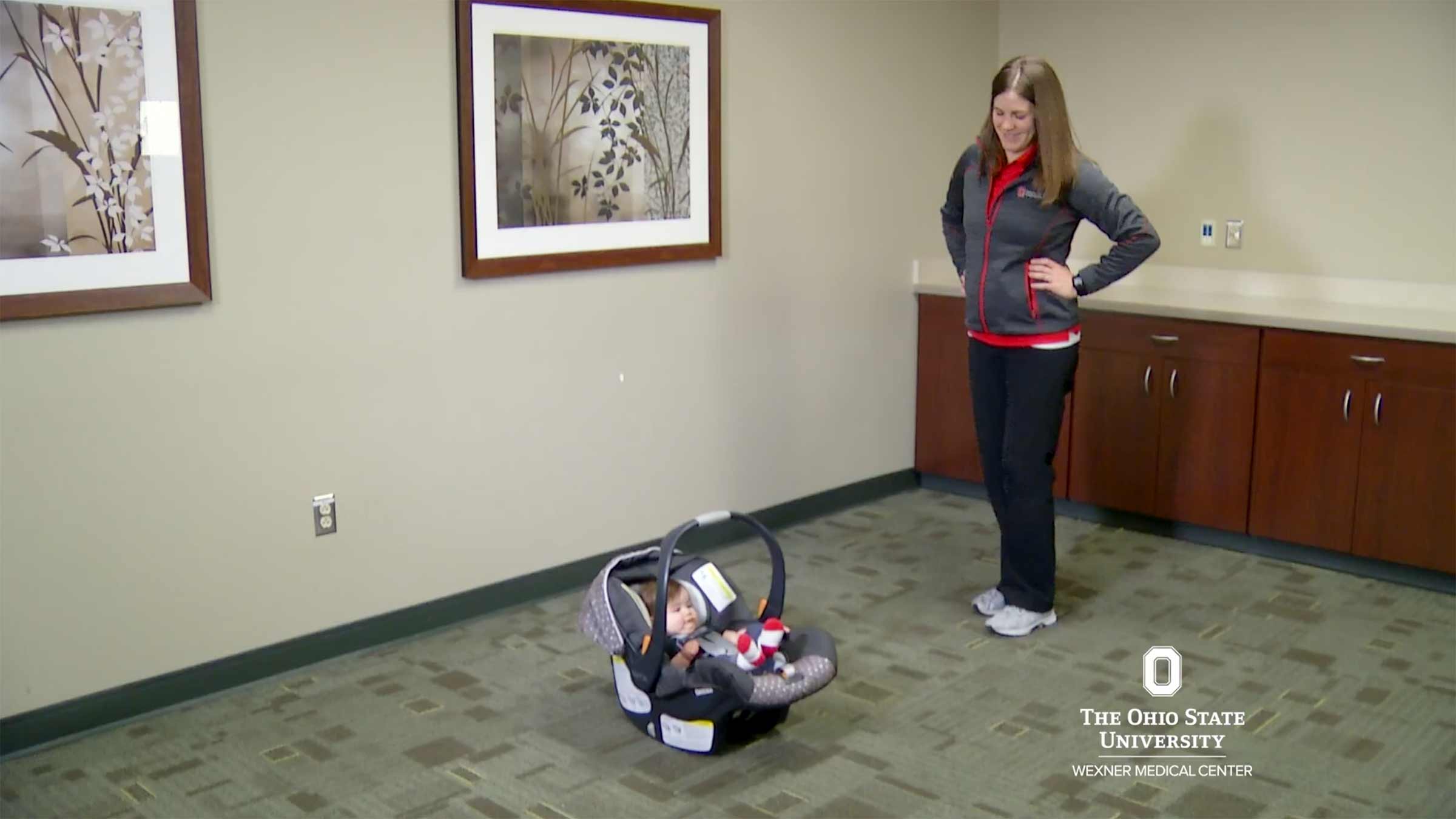 A physical therapist getting ready to demonstrate how to lift up a car seat