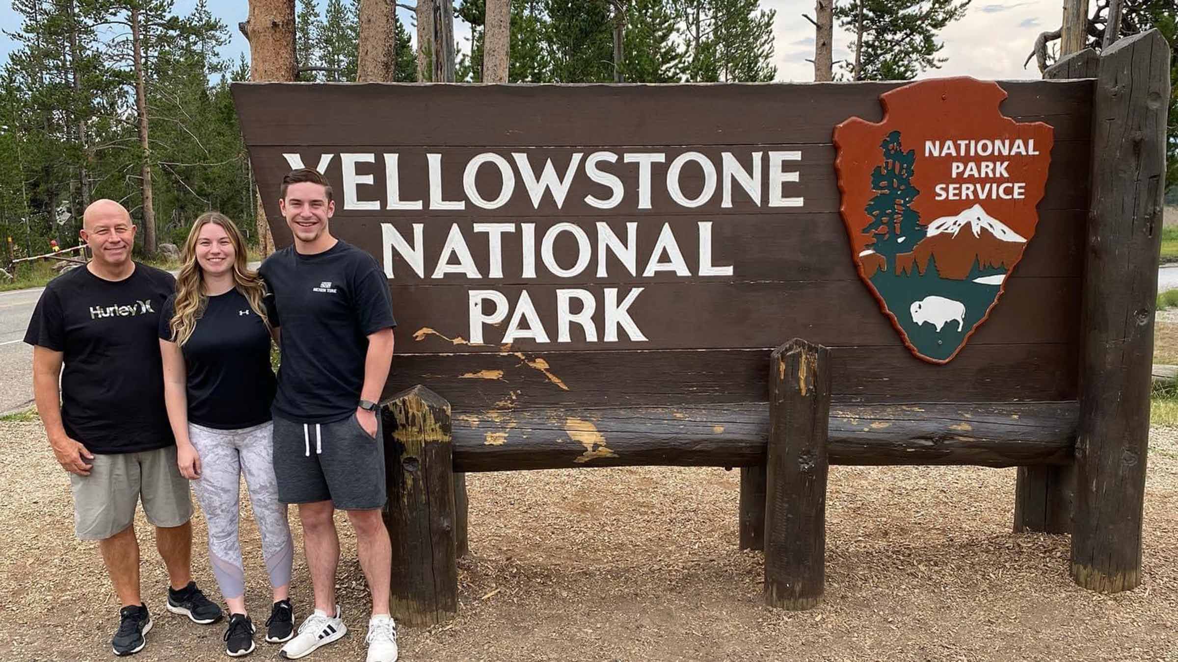 Carmen Zone with his kids next to the Yellowstone National Park sign