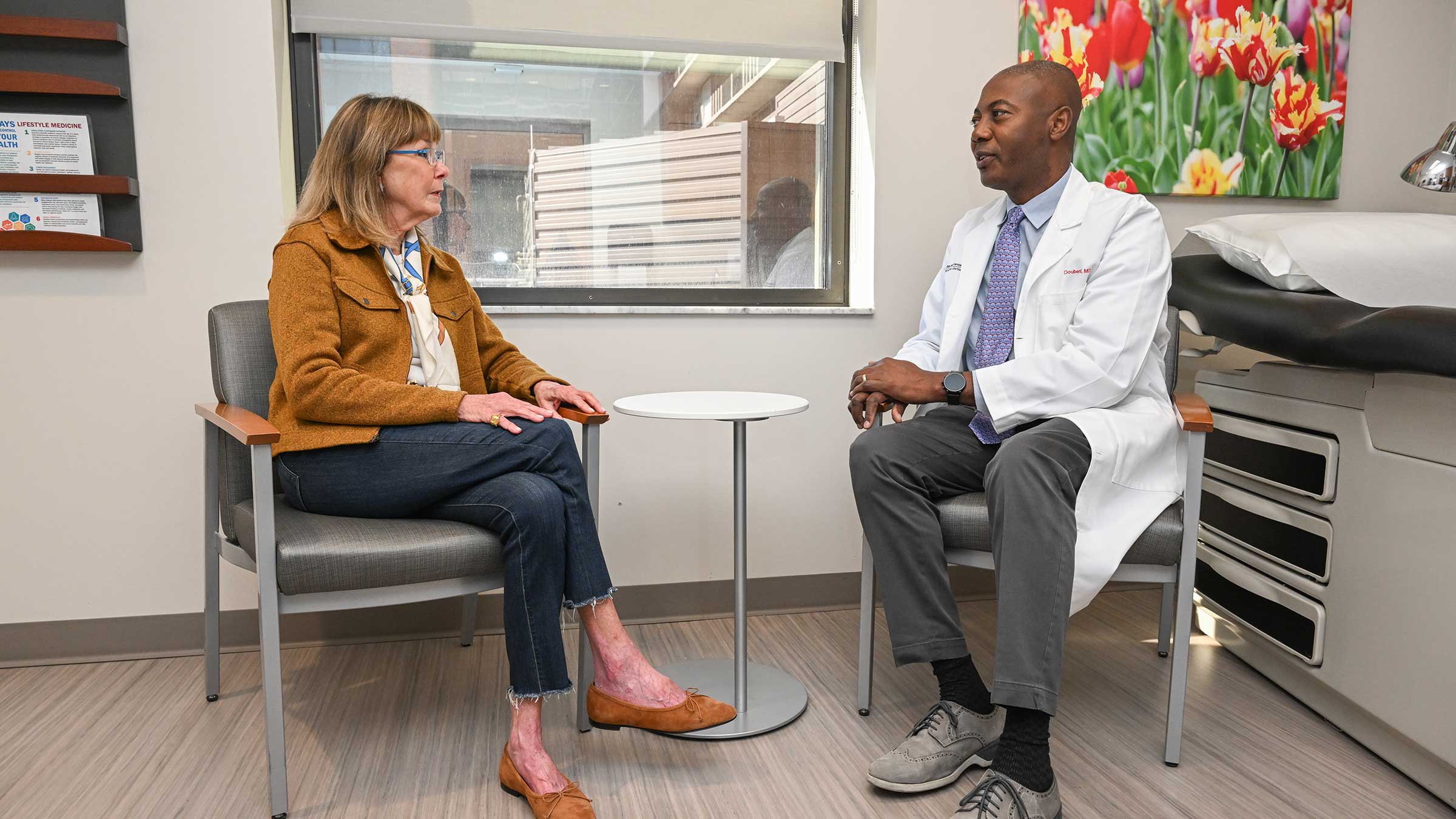 Dr. Chyke Doubeni conversing with lung cancer patient, Laura Dehlendorf