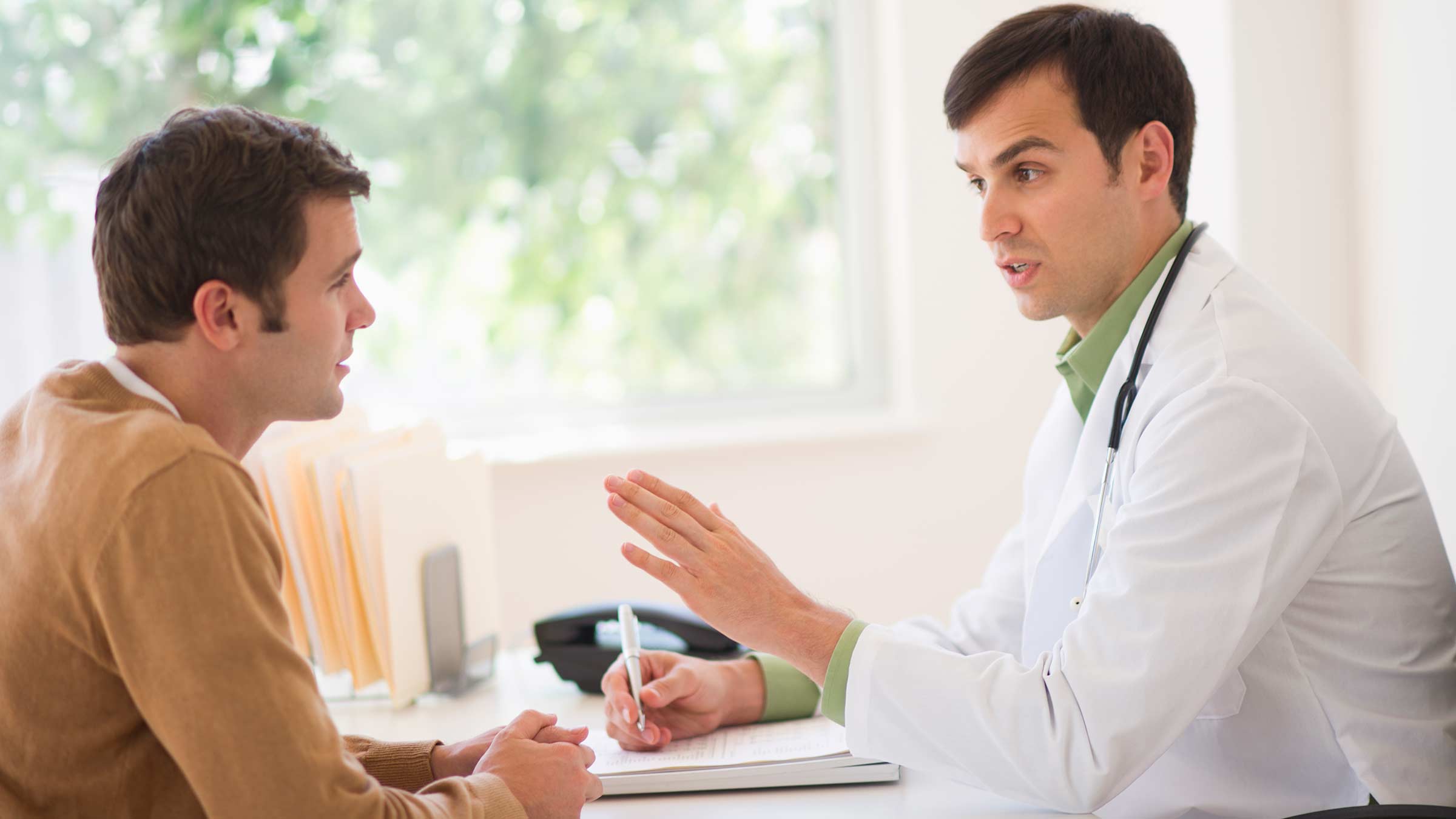 A male patient talking with his male primary care provider